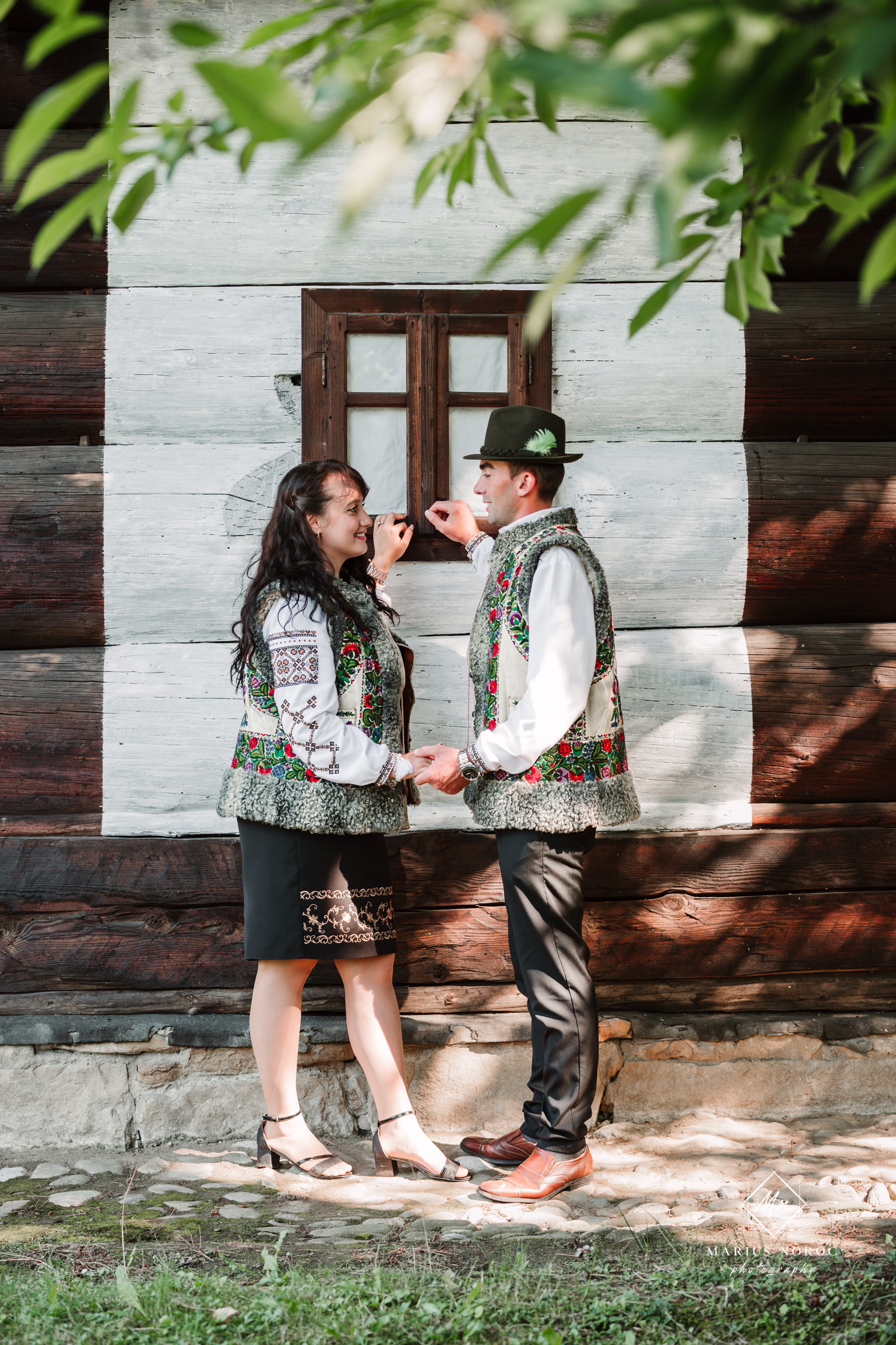 Sabina și Ionuț, îmbrăcați în costume populare bucovinene, au realizat o ședință foto "Save the Date" la Muzeul Satului Bucovinean din Suceava. Fotografii tradiționale și romantice, surprinse într-un peisaj autentic și istoric, evidențiind dragostea și frumusețea tradițiilor locale.