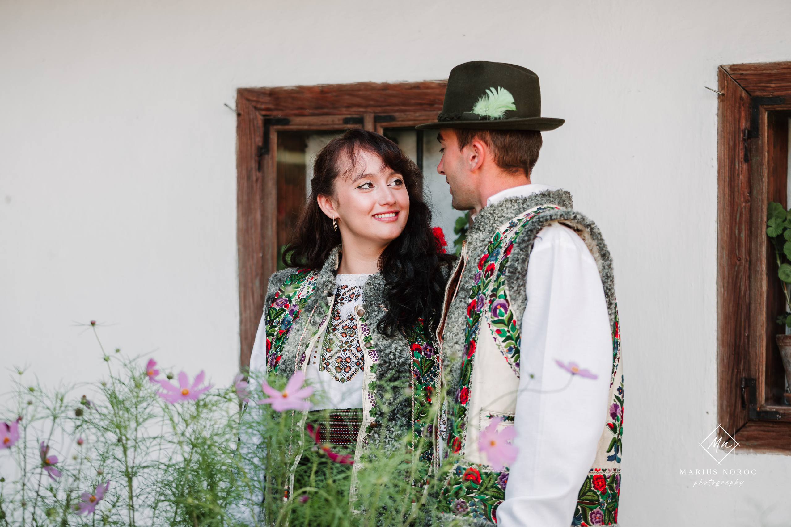 Sabina și Ionuț, îmbrăcați în costume populare bucovinene, au realizat o ședință foto "Save the Date" la Muzeul Satului Bucovinean din Suceava. Fotografii tradiționale și romantice, surprinse într-un peisaj autentic și istoric, evidențiind dragostea și frumusețea tradițiilor locale.