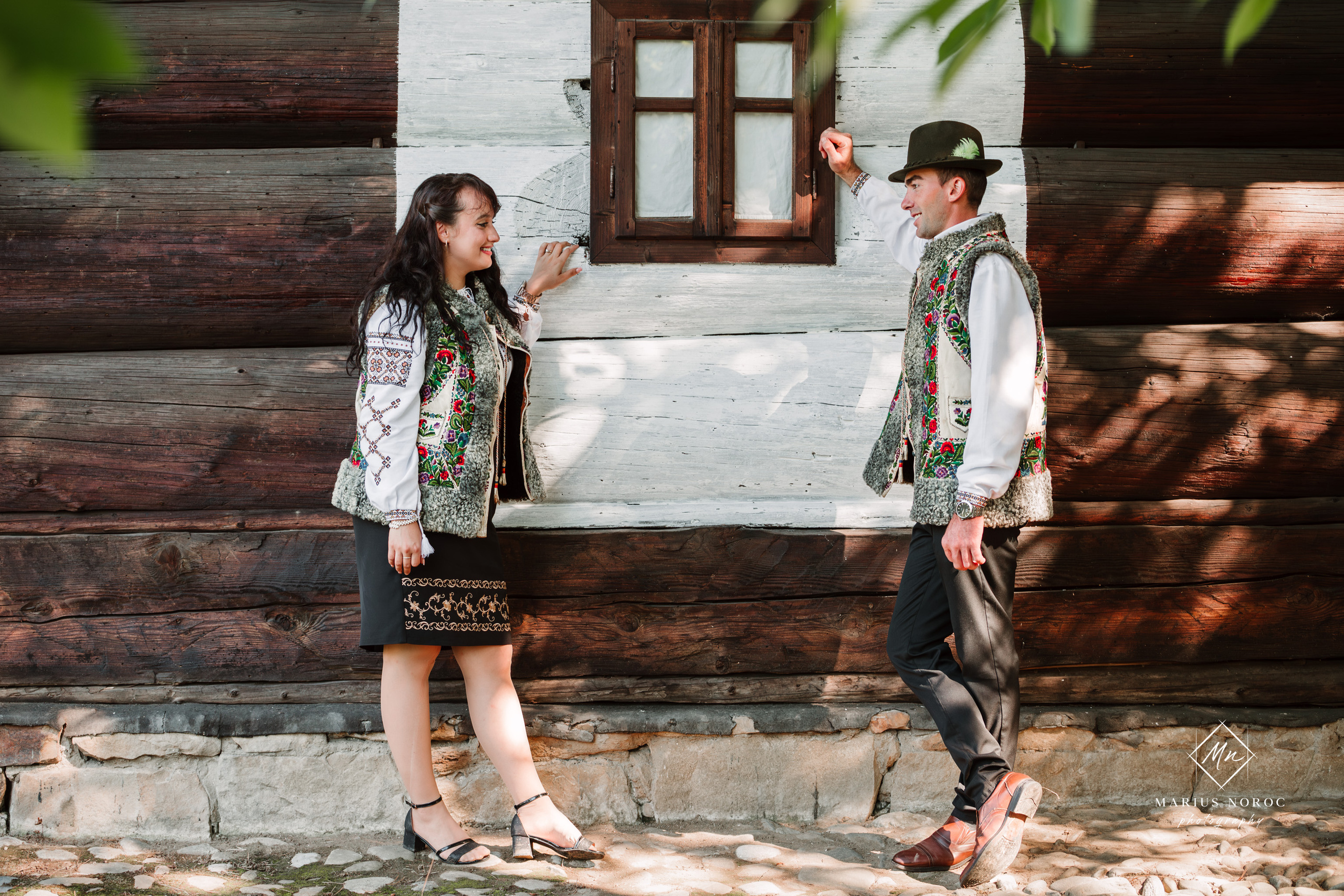 Sabina și Ionuț, îmbrăcați în costume populare bucovinene, au realizat o ședință foto "Save the Date" la Muzeul Satului Bucovinean din Suceava. Fotografii tradiționale și romantice, surprinse într-un peisaj autentic și istoric, evidențiind dragostea și frumusețea tradițiilor locale.