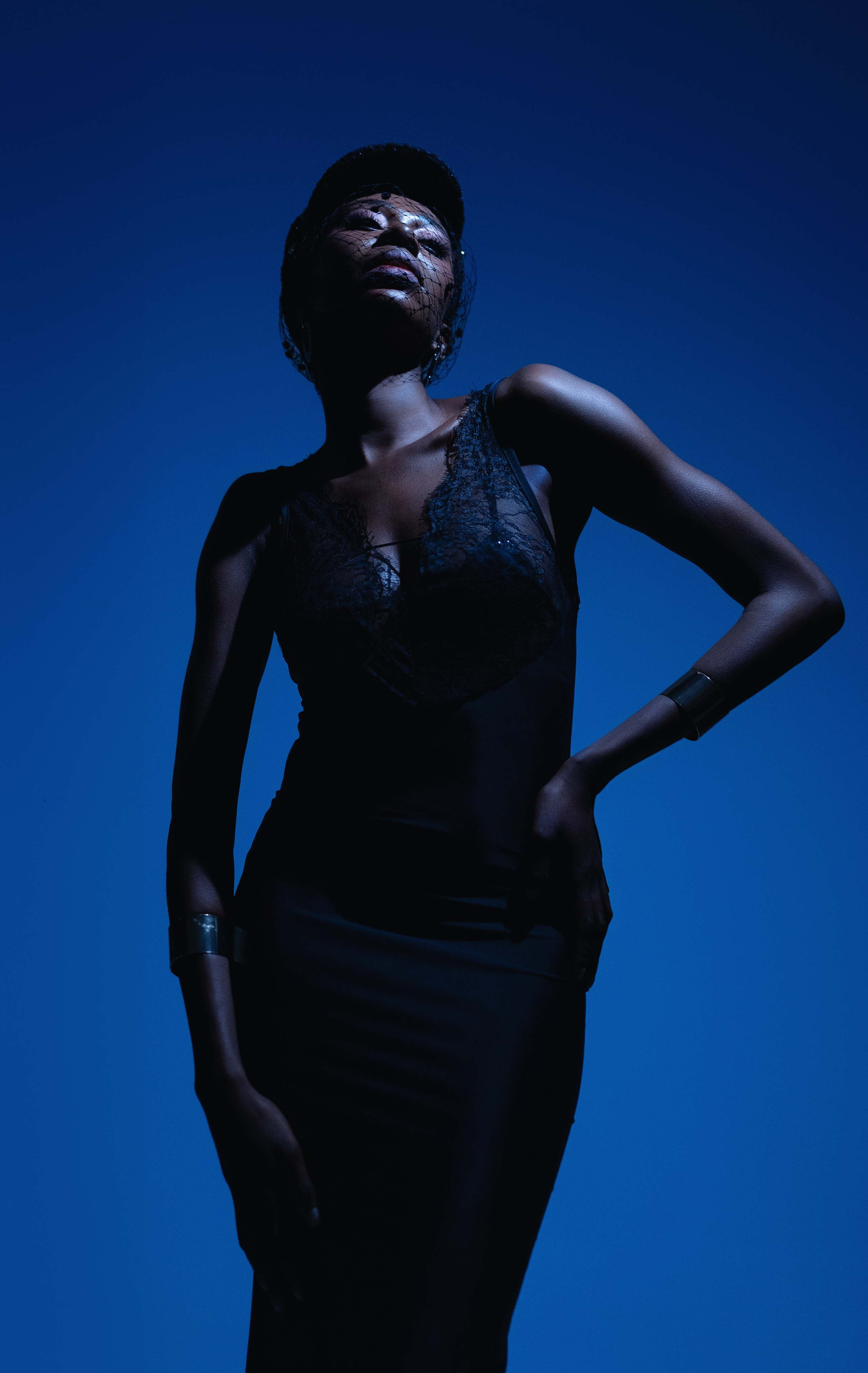 High-Contrast Fashion Portrait with Dramatic Studio Lighting – A high-contrast fashion portrait of a model in a black outfit, lit with strong directional lighting to create sharp shadows and highlight the textures of the clothing.