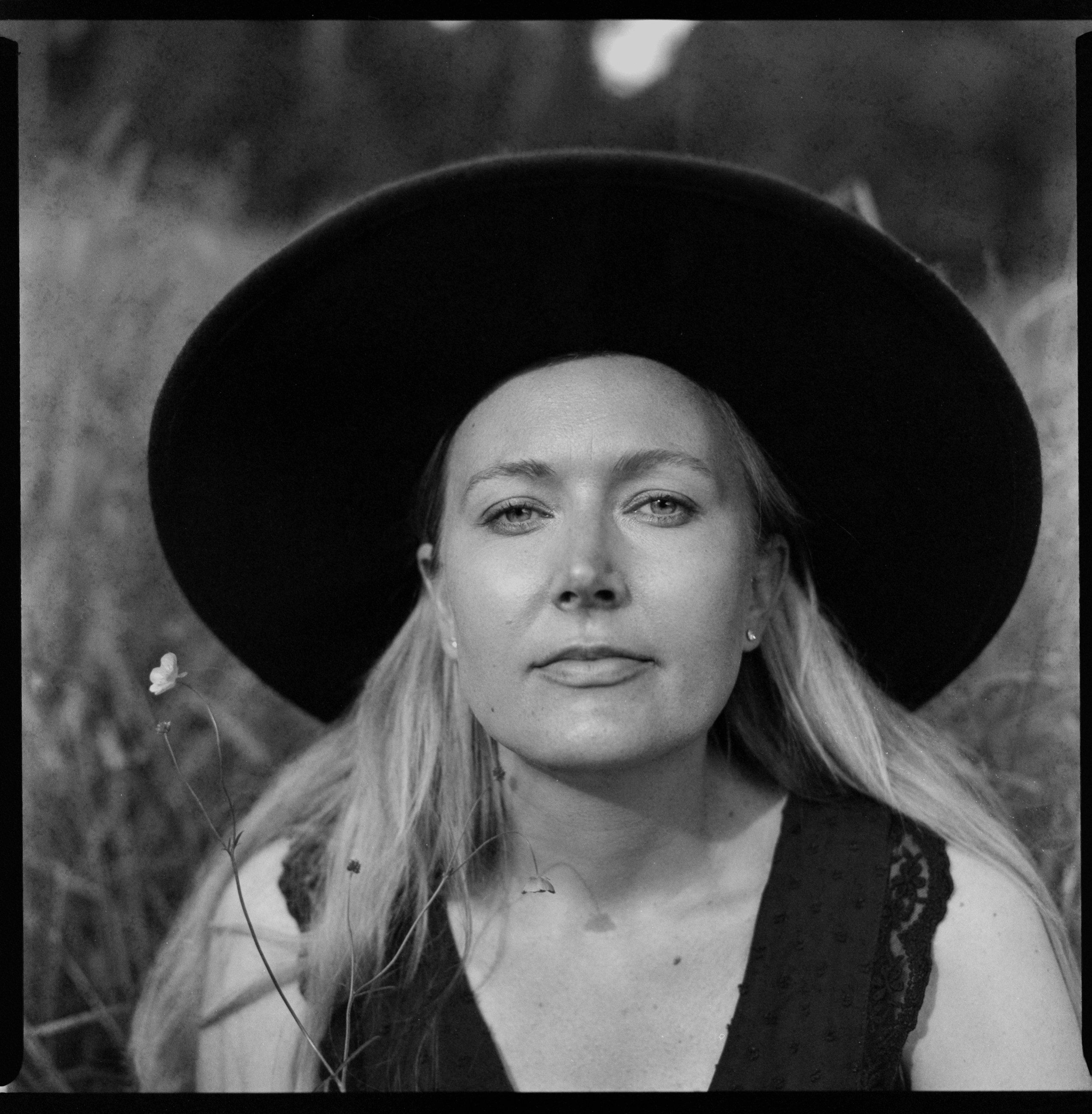 Natural light portrait of a woman in a wide-brim hat, shot on medium format film near Tettnang
