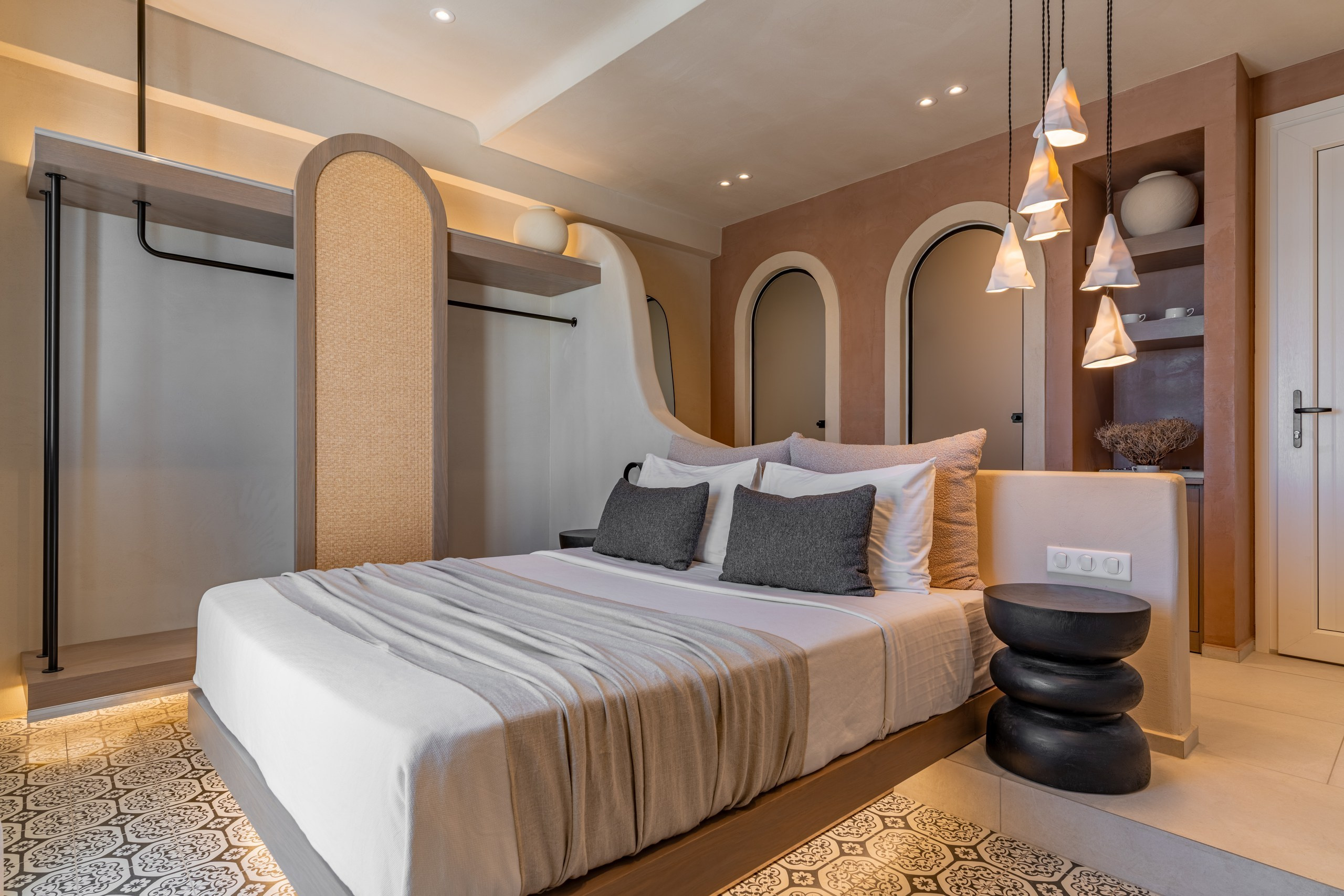 Luxurious master suite at Atlantic Astypalaia, featuring vaulted Cycladic architecture and stylish dark side stools. Visual Storytelling by photographer George Katsaelis and designer Fotis Bakas.