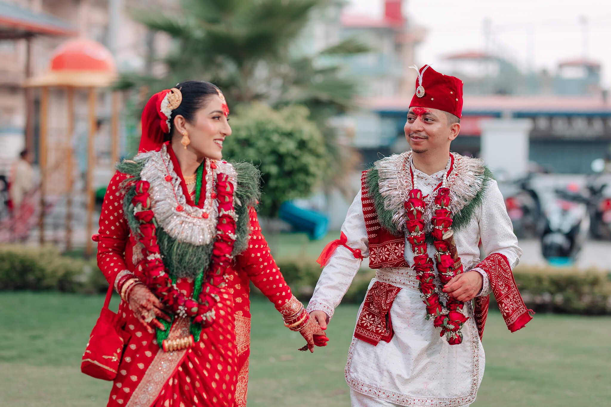 Beautiful candid outdoor wedding photoshoot of a traditional Hindu bride and groom smiling at each other. Wedding photoshoot in Nepal.