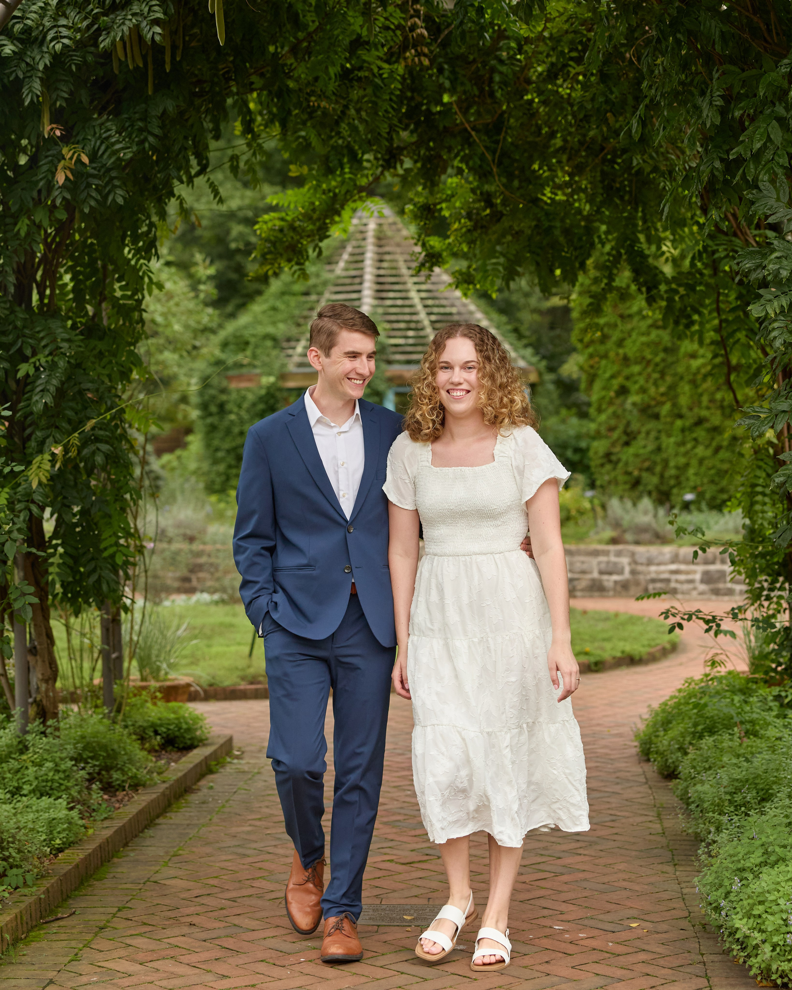 Couple strolling beneath an ivy-covered arch at Inniswood Metro Gardens