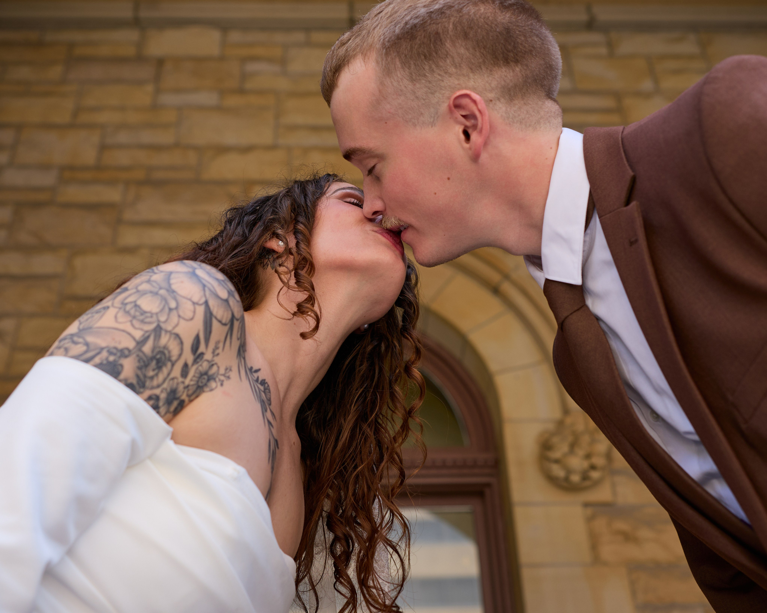 Close-up kiss against a sandstone wall in downtown Columbus, Ohio