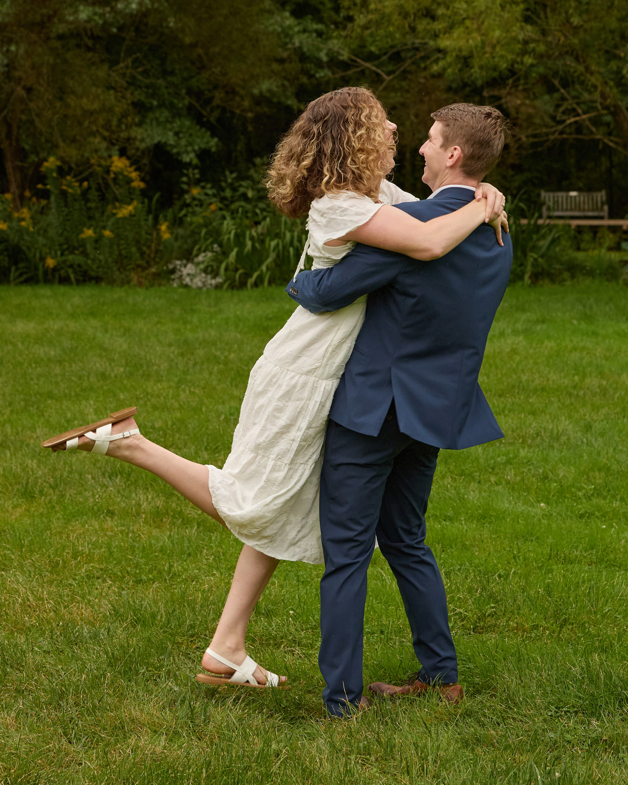 Happy lift in a sunny meadow during an engagement session at Inniswood, Ohio