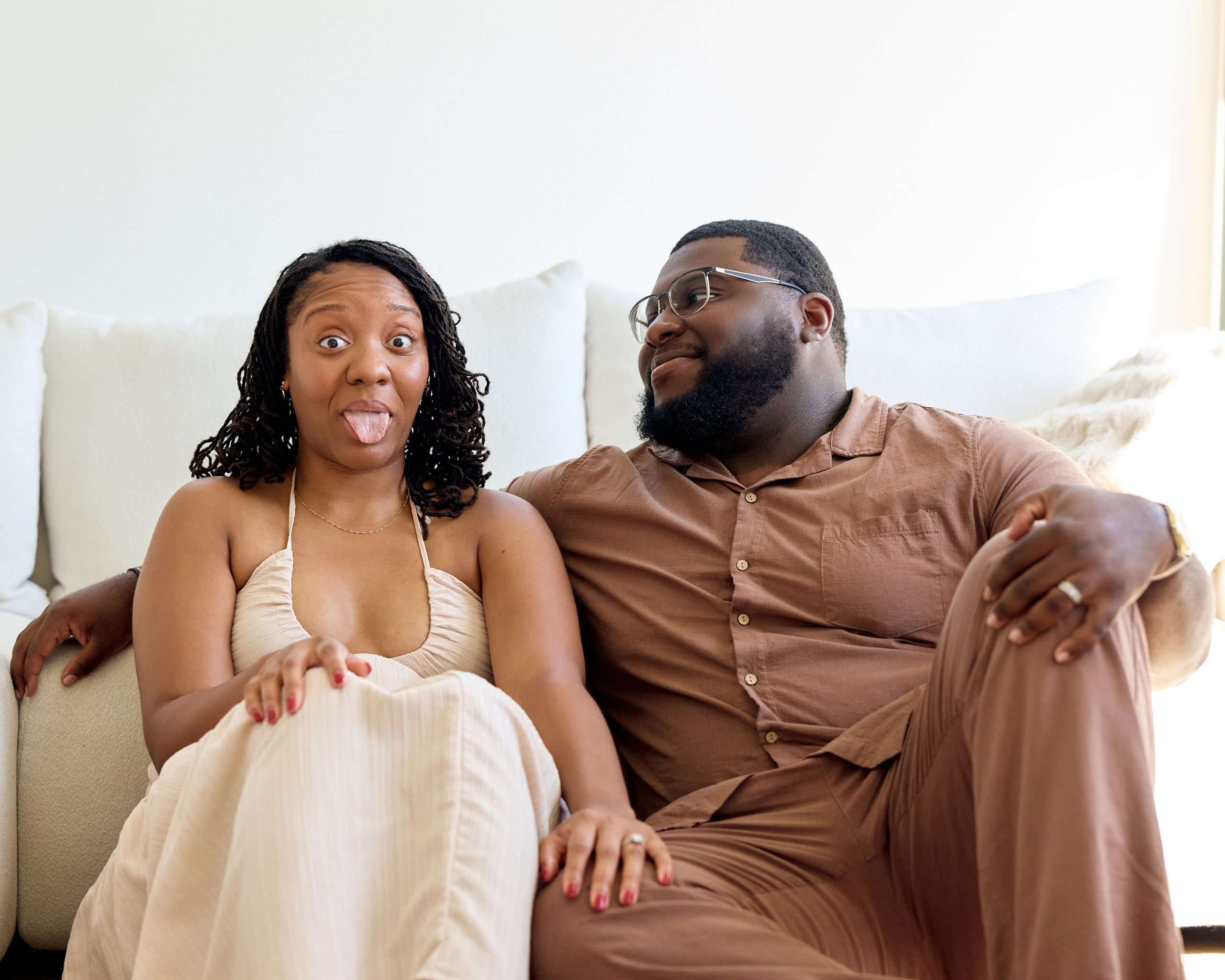 Laughing together on a couch during a studio engagement session in Ohio