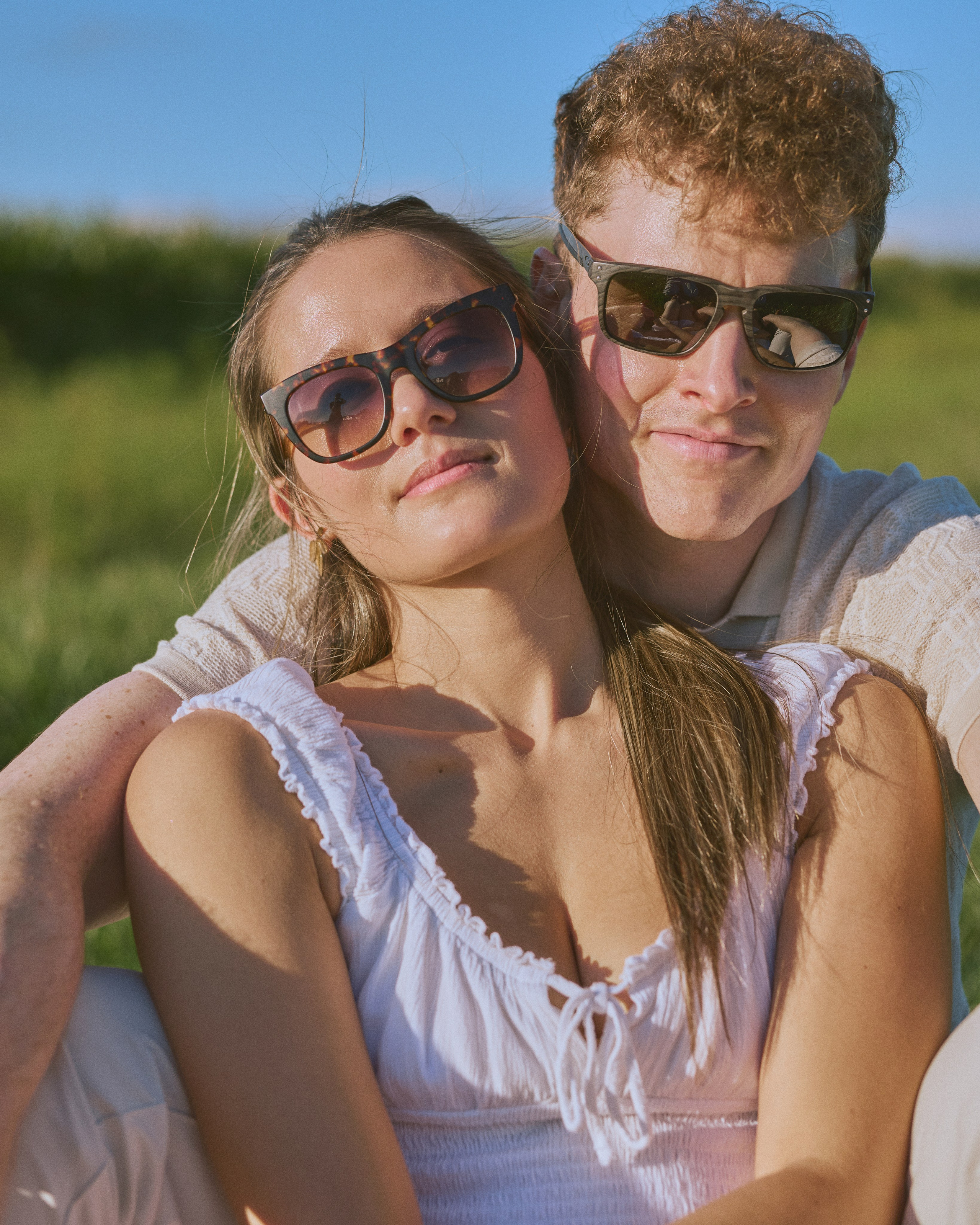 Smiling couple in sunglasses during a summer engagement shoot near Columbus