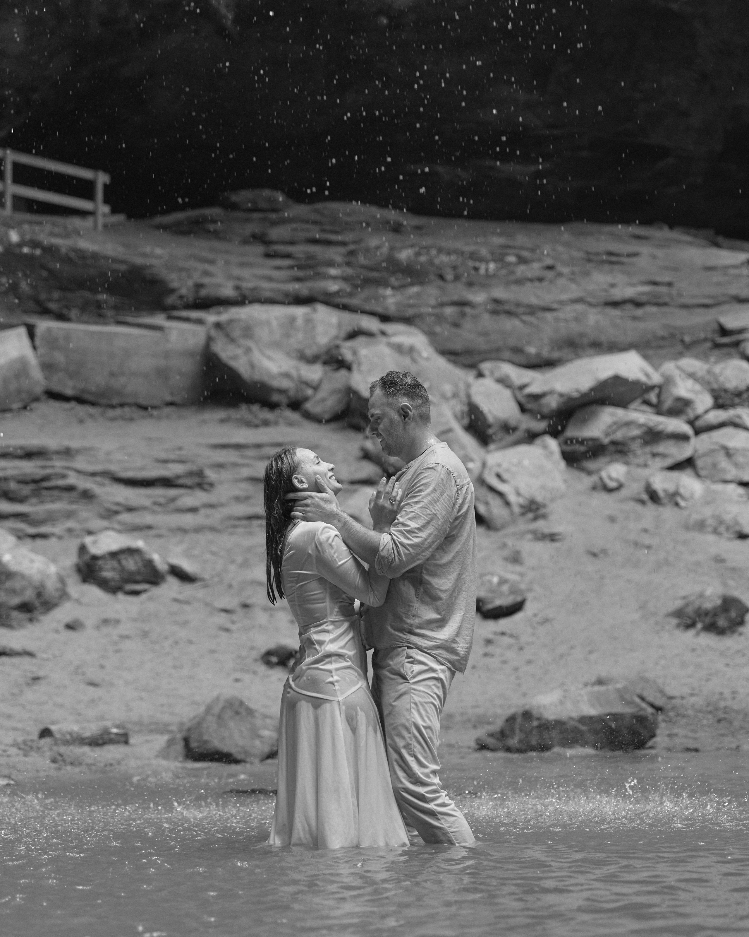 Black and white wide shot of a couple in the stream under the cave, Ohio
