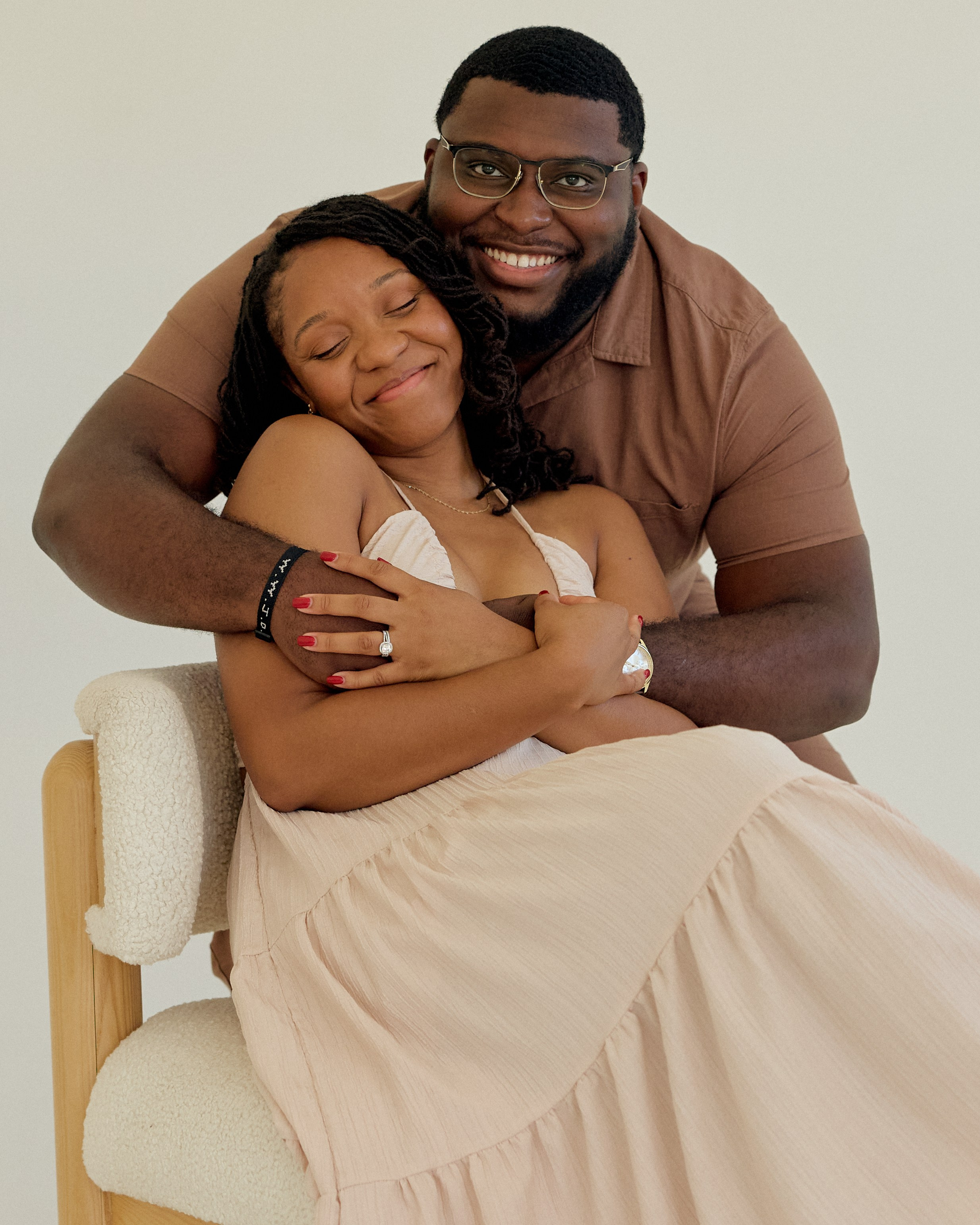 Warm embrace in an armchair during a studio engagement shoot in Columbus, Ohio