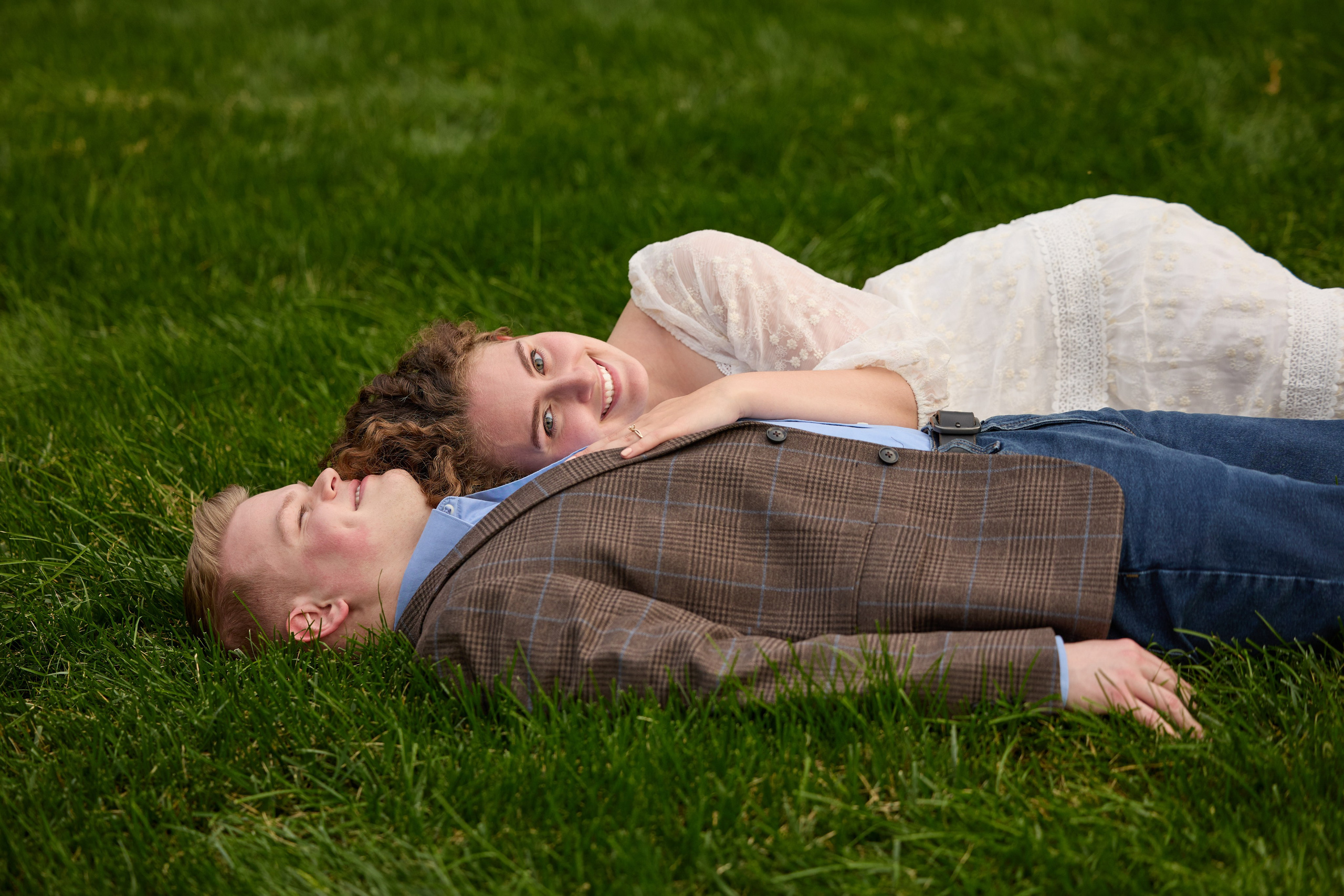 Couple lying together on the grass during an engagement shoot in Ohio
