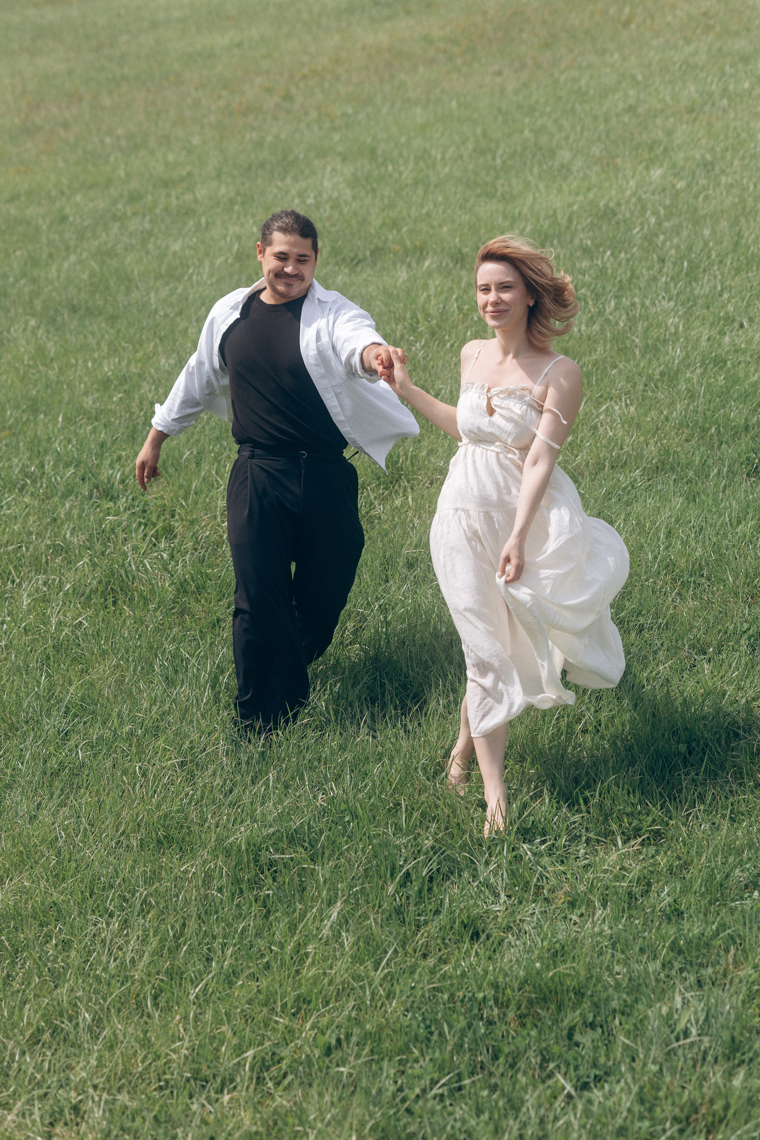 Happy run through the meadow during an engagement shoot near Columbus, Ohio
