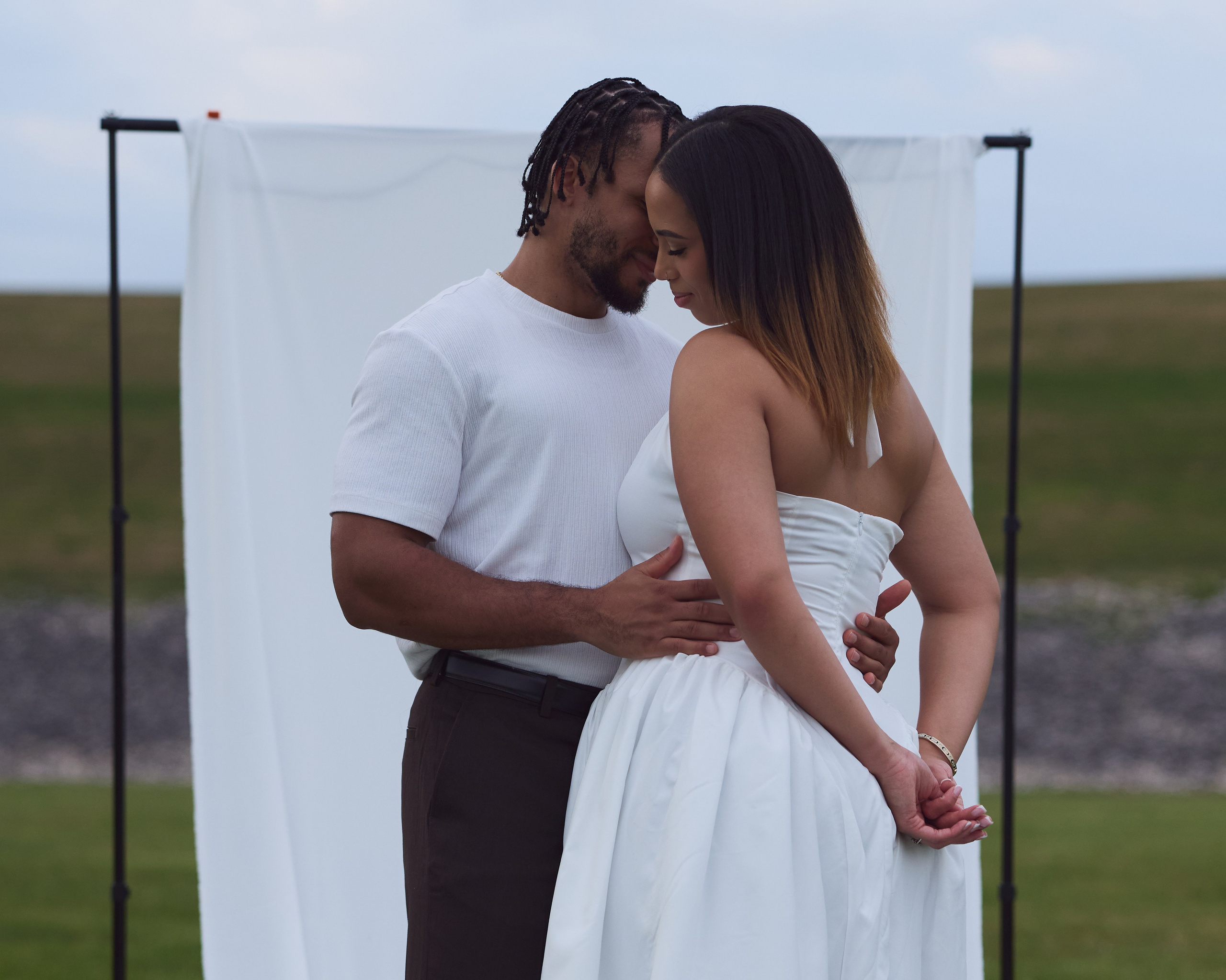 Warm embrace before a white backdrop during an Ohio engagement shoot