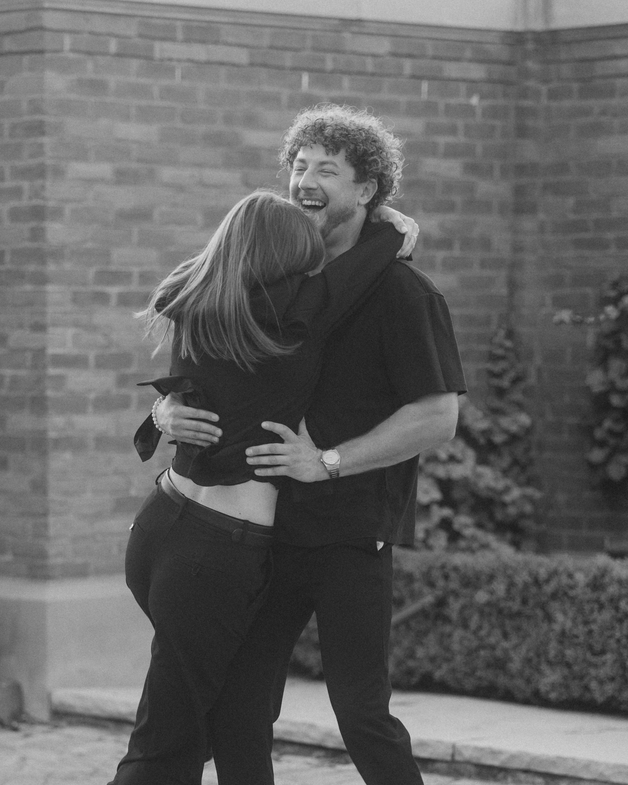 Black and white embrace against a brick wall in German Village, Columbus