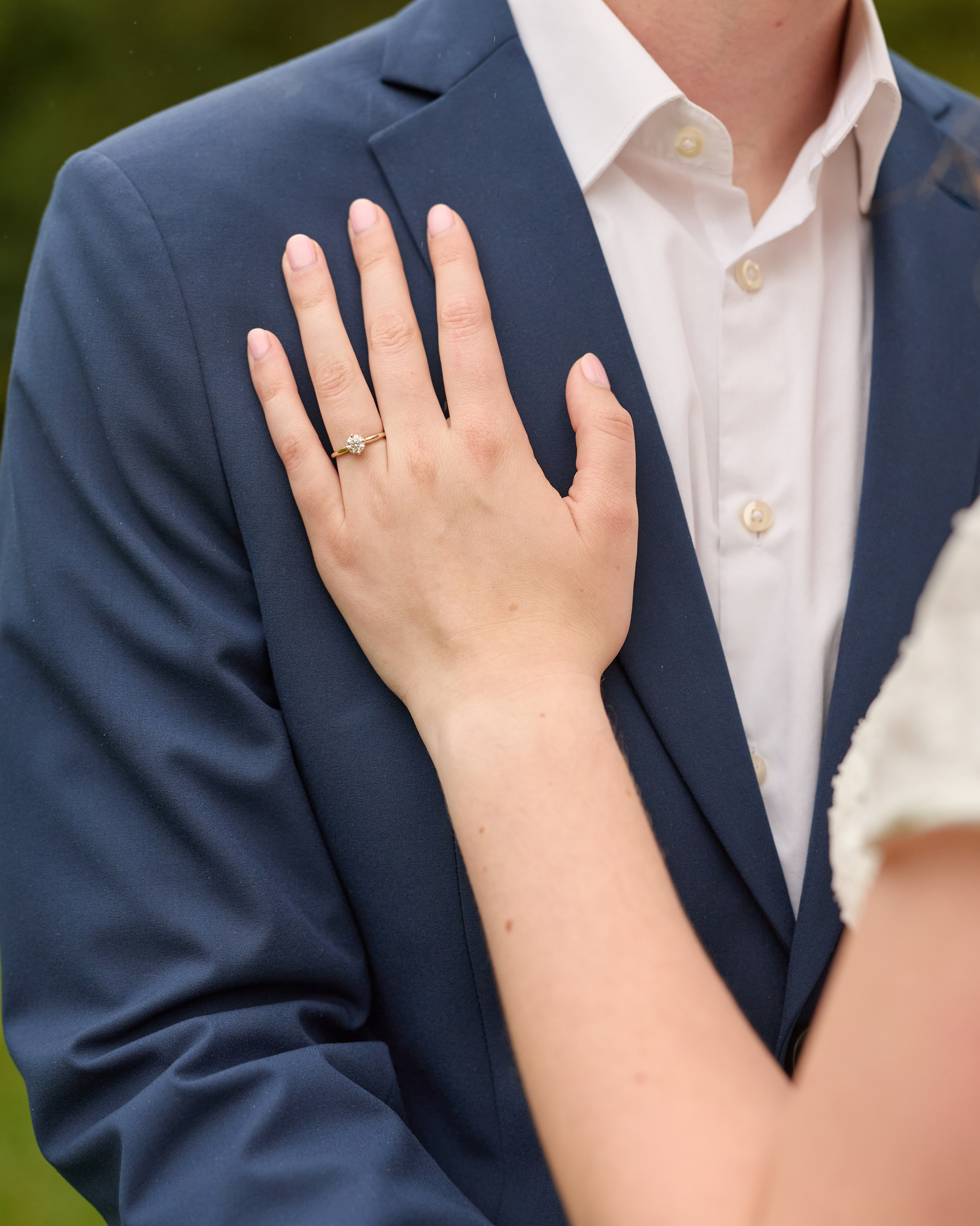 Her hand with the engagement ring resting on his chest at Inniswood Gardens