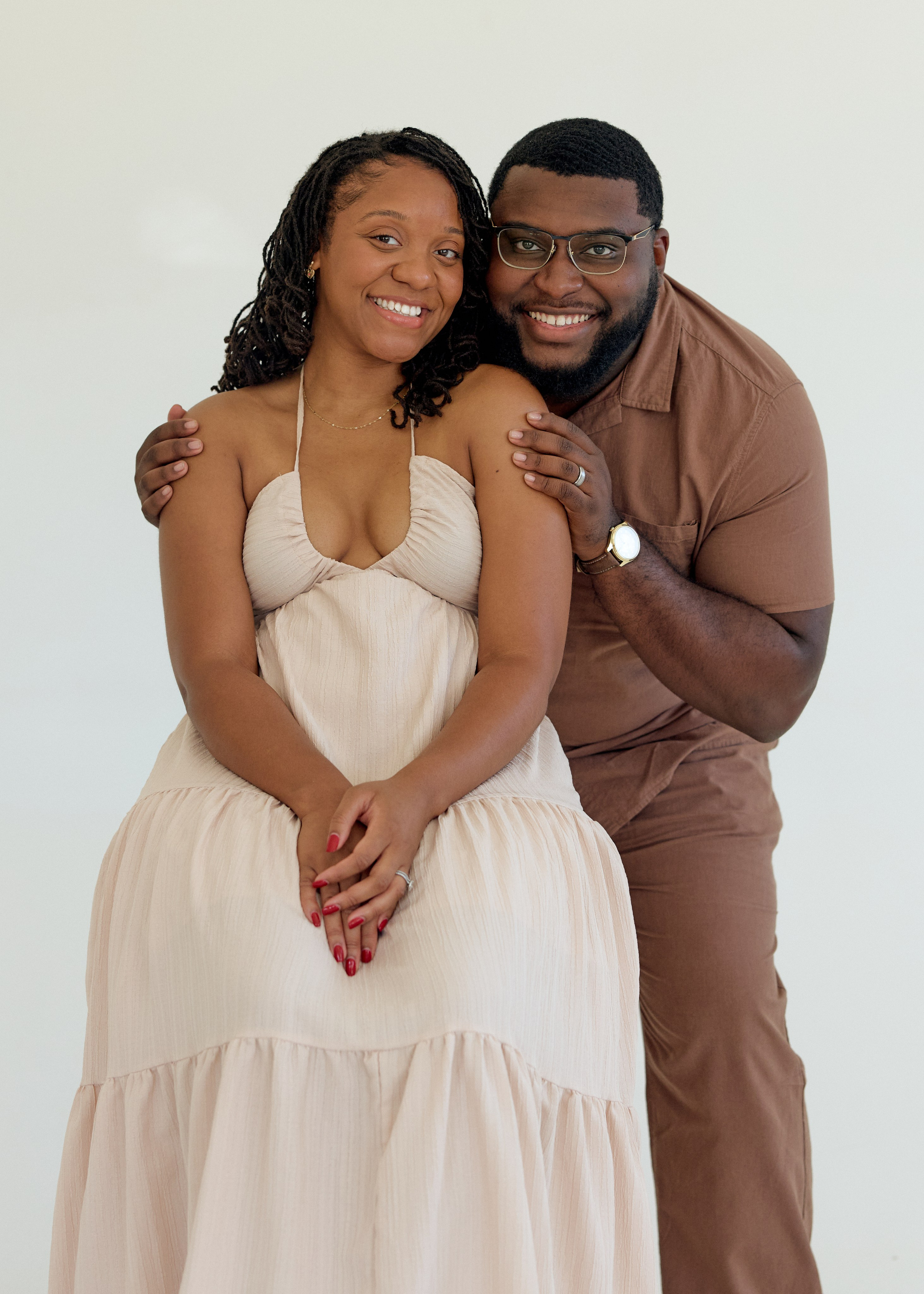 Cozy embrace against a white studio backdrop during a Columbus engagement session
