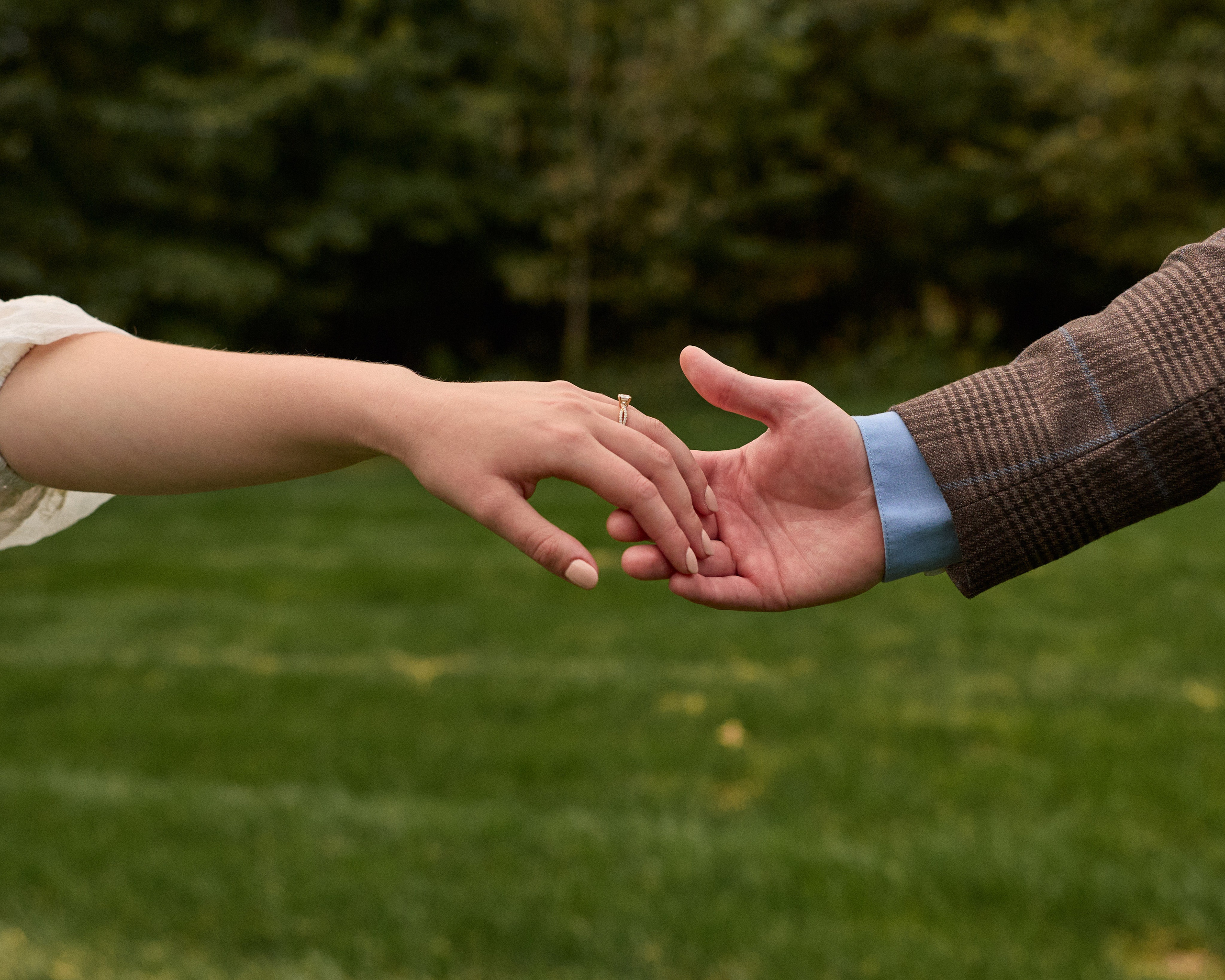 Close-up of intertwined hands during an engagement session at Swan Lake, Ohio