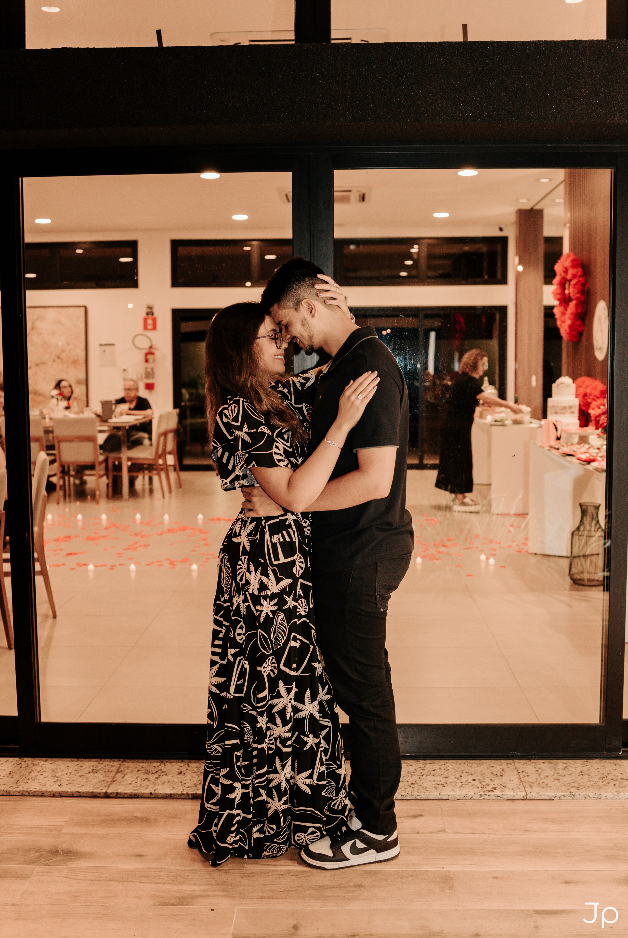 Abraço entre o casal em frente à entrada do local da cerimônia em Bauru.
