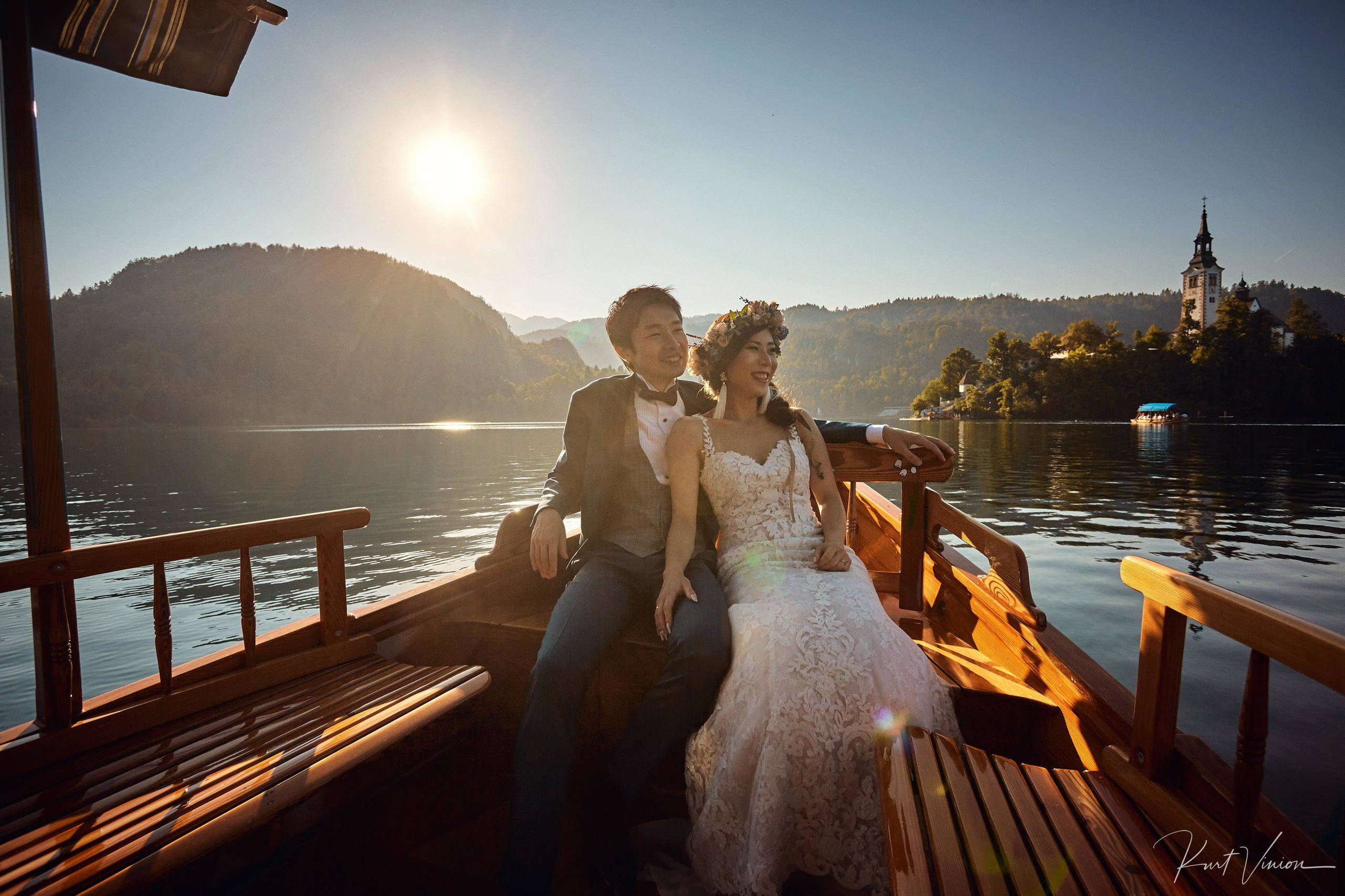 Happy couple on traditional pletna boat Lake Bled golden hour.