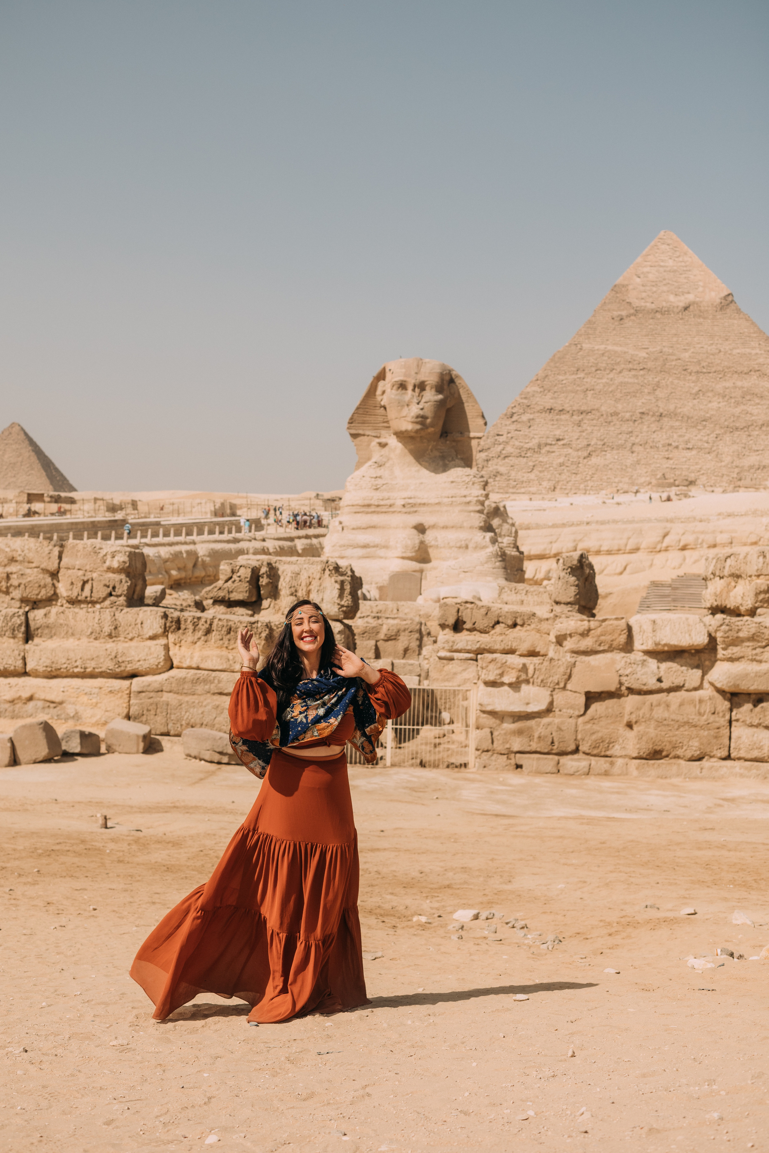 Девушка из чикаго в оранжевом длинном платье на фоне Сфинкса