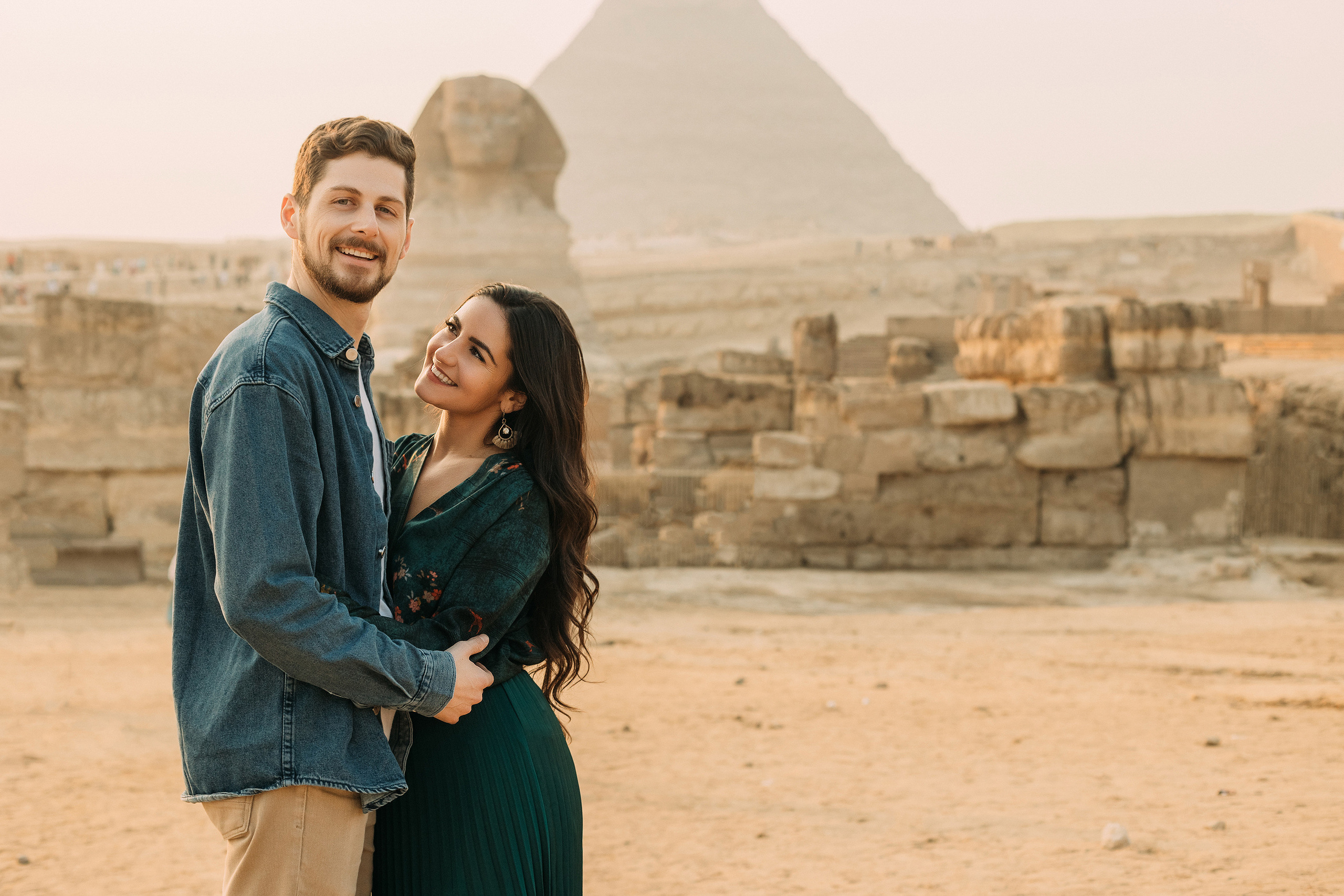 влюбленная пара в закатном свете на фоне Сфинкса и египетской пирамиды