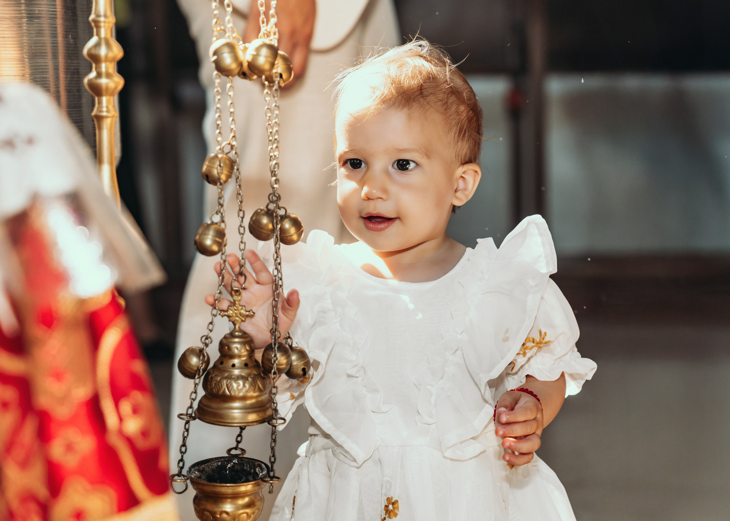 Devojčica u beloj haljini na dan krštenja