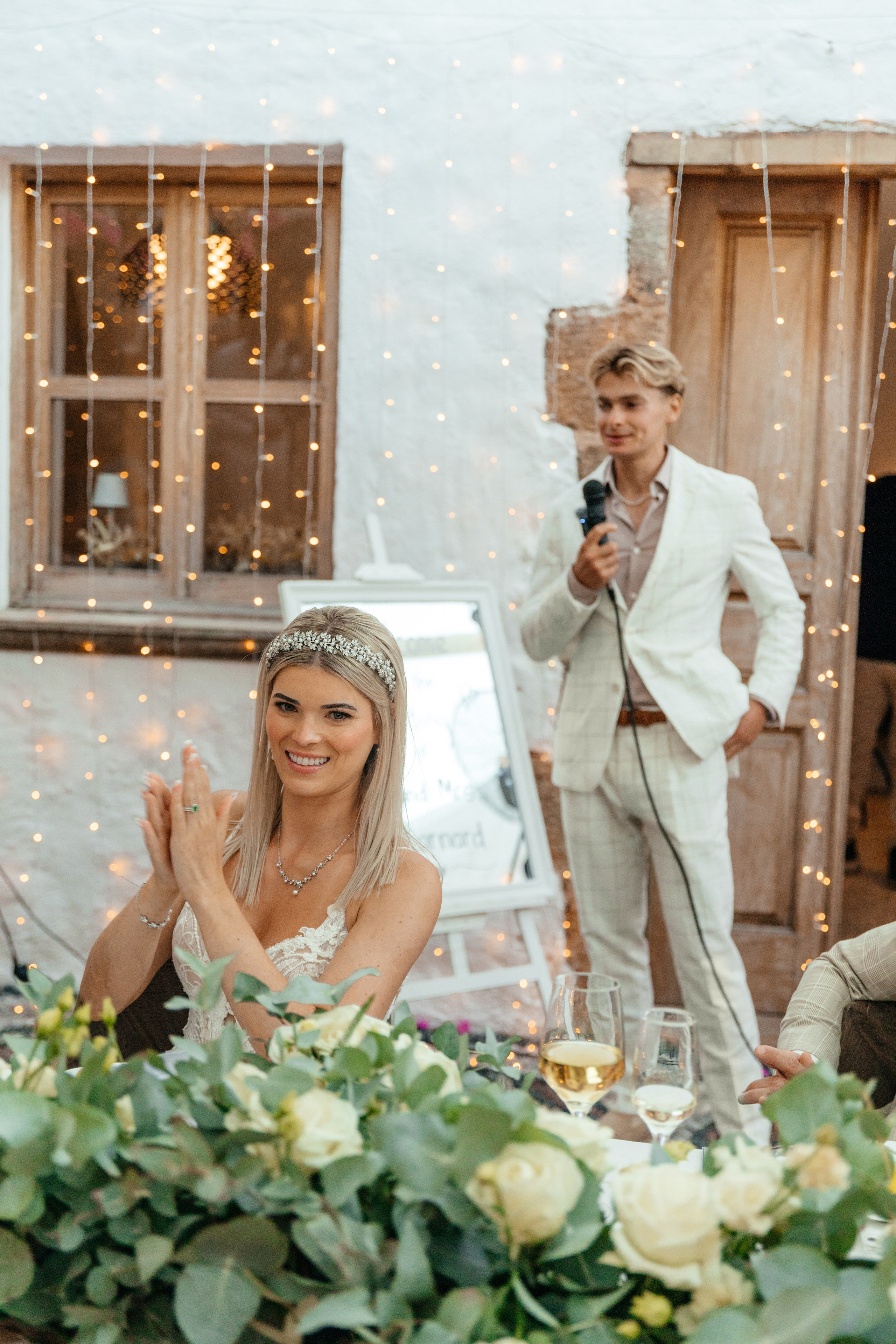 Bride is clapping her hands during a humorous wedding speech by her brother at a charming restaurant in Lindos,Greece, Rhodes .