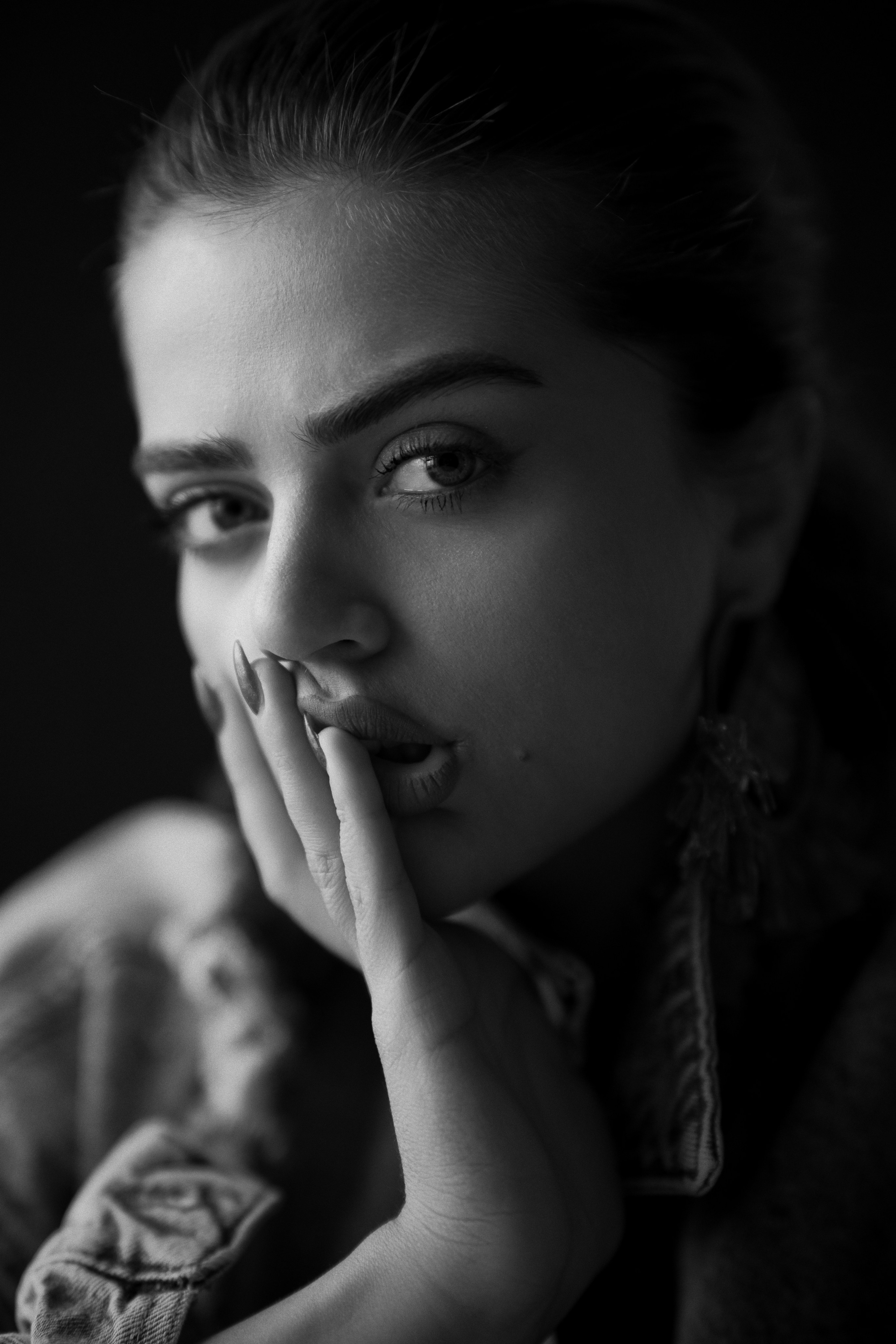 Fine art black and white female portrait photography by Mehran Hadad featuring an expressive close-up with elegant styling.