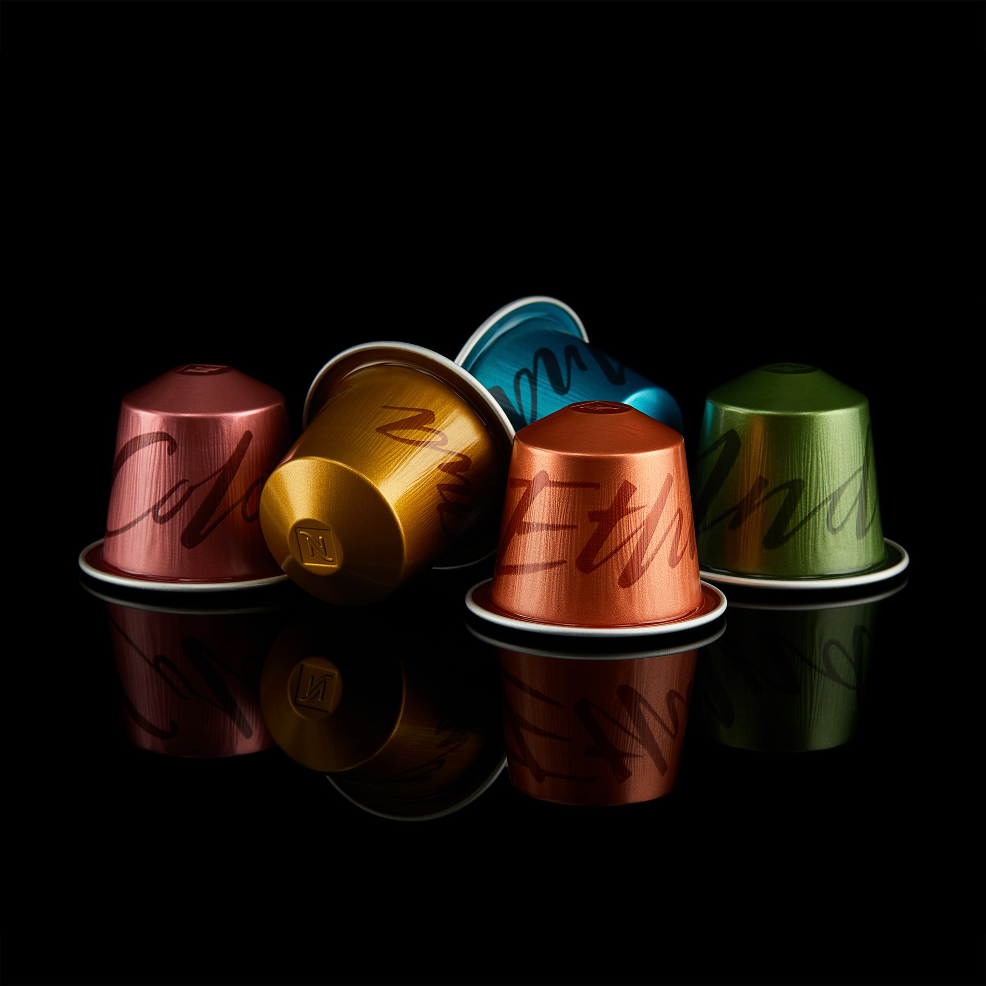 Photographer Roman Djuzev - Capsule coffee by Nespresso, Master Origins series, close-up on a black background with reflection.