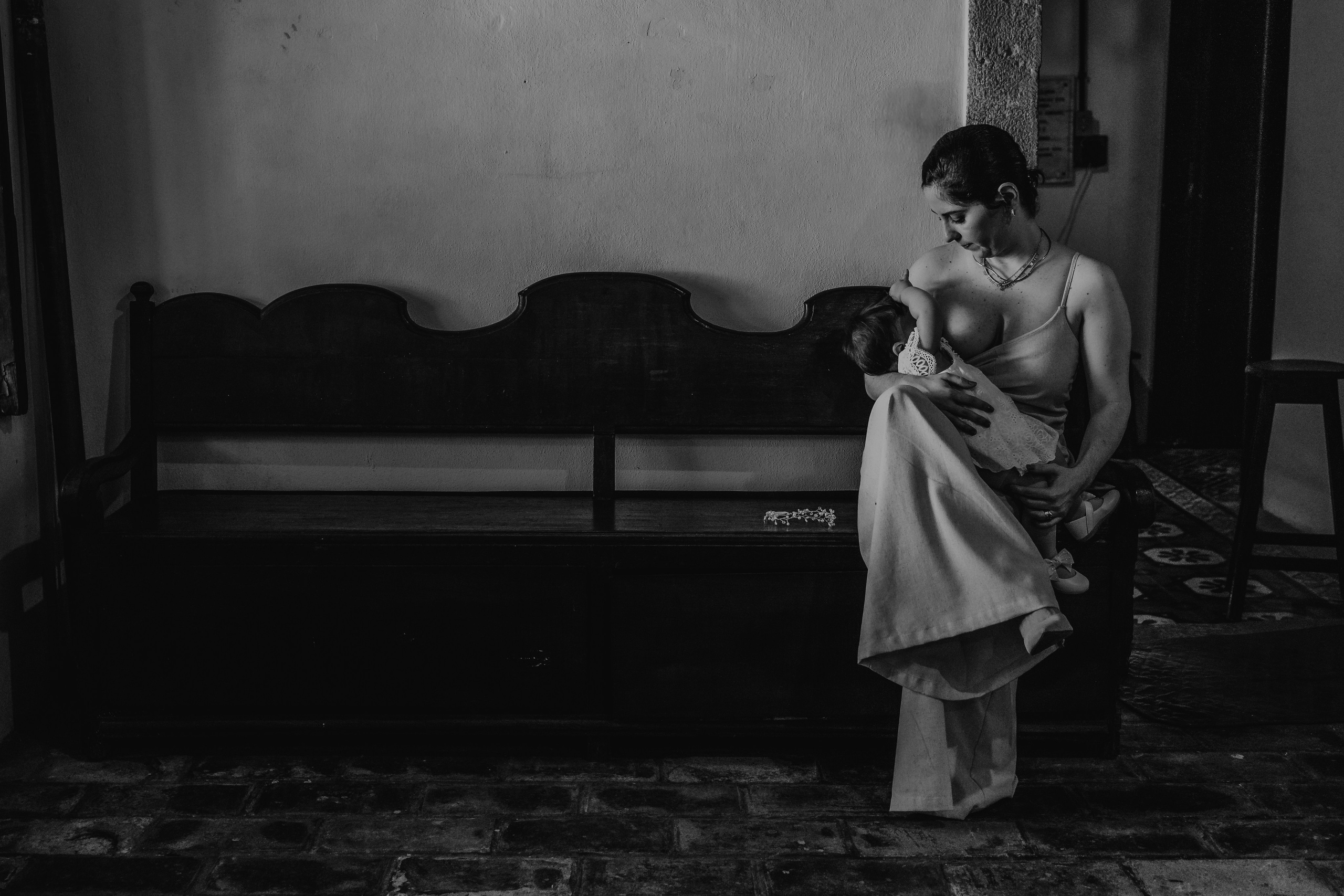 Mãe amamentando em pausa antes do batizado
