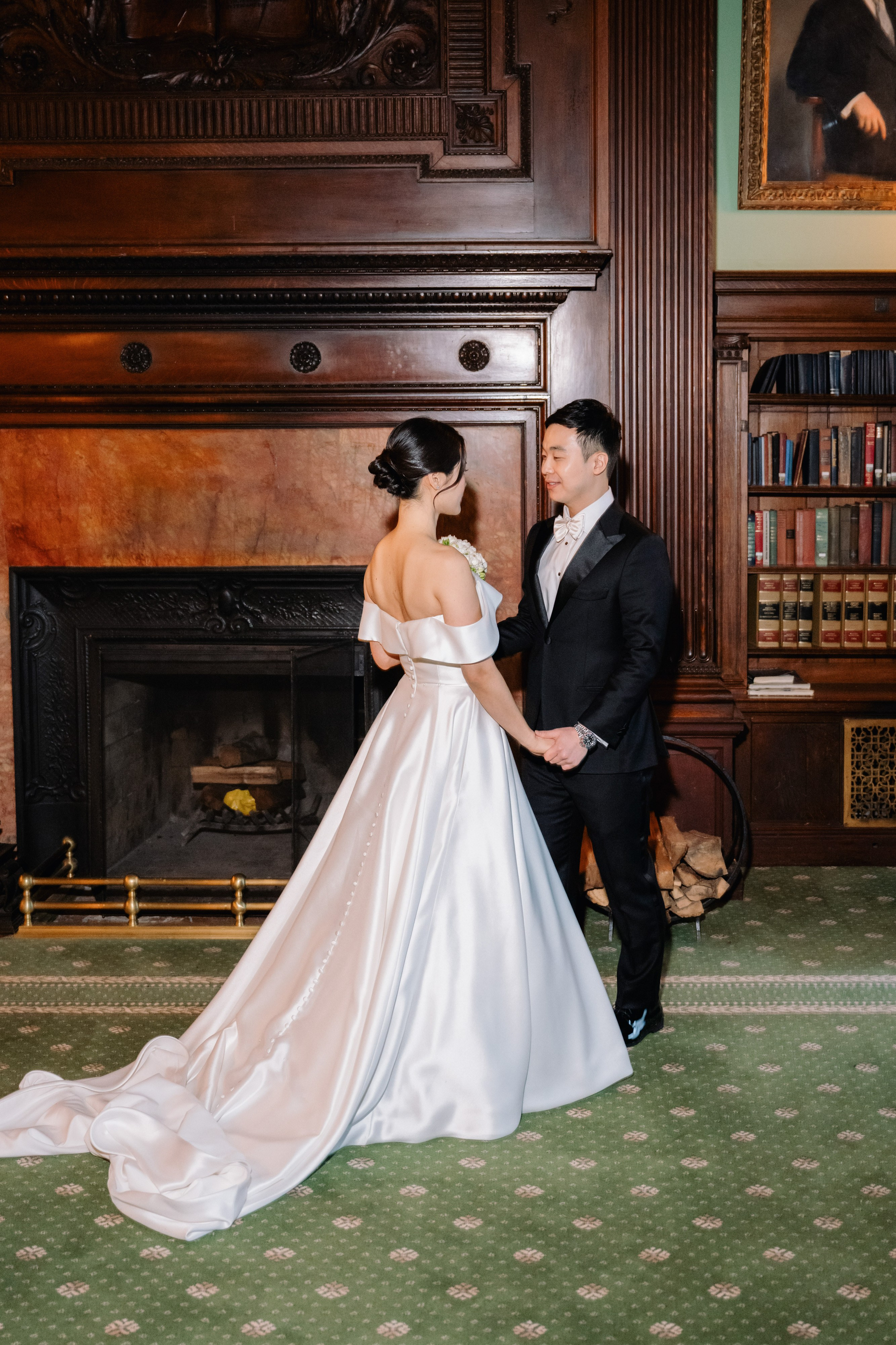 a bride and groom in front of a fireplace