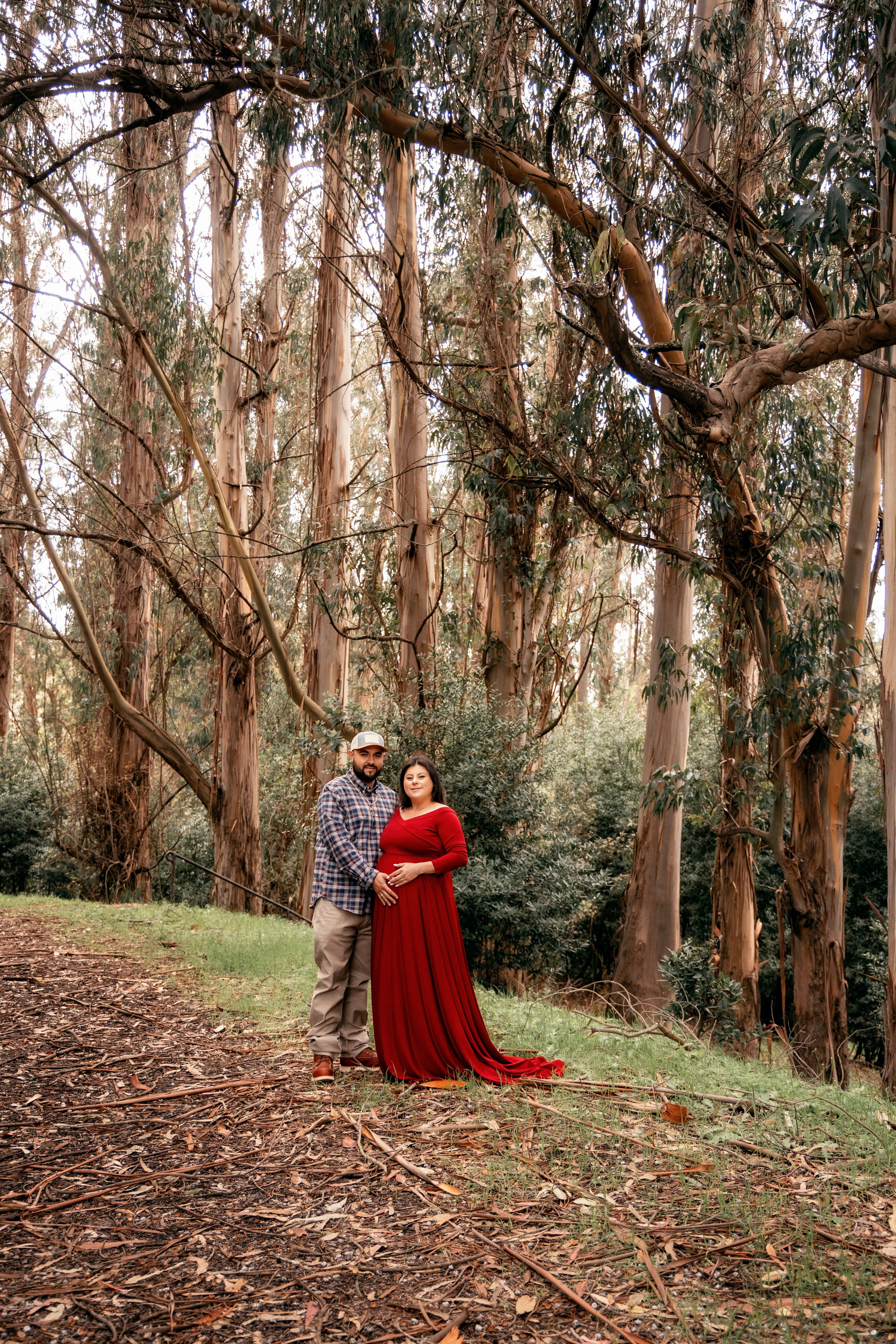 Pregnant woman walking through a park surrounded by greenery
