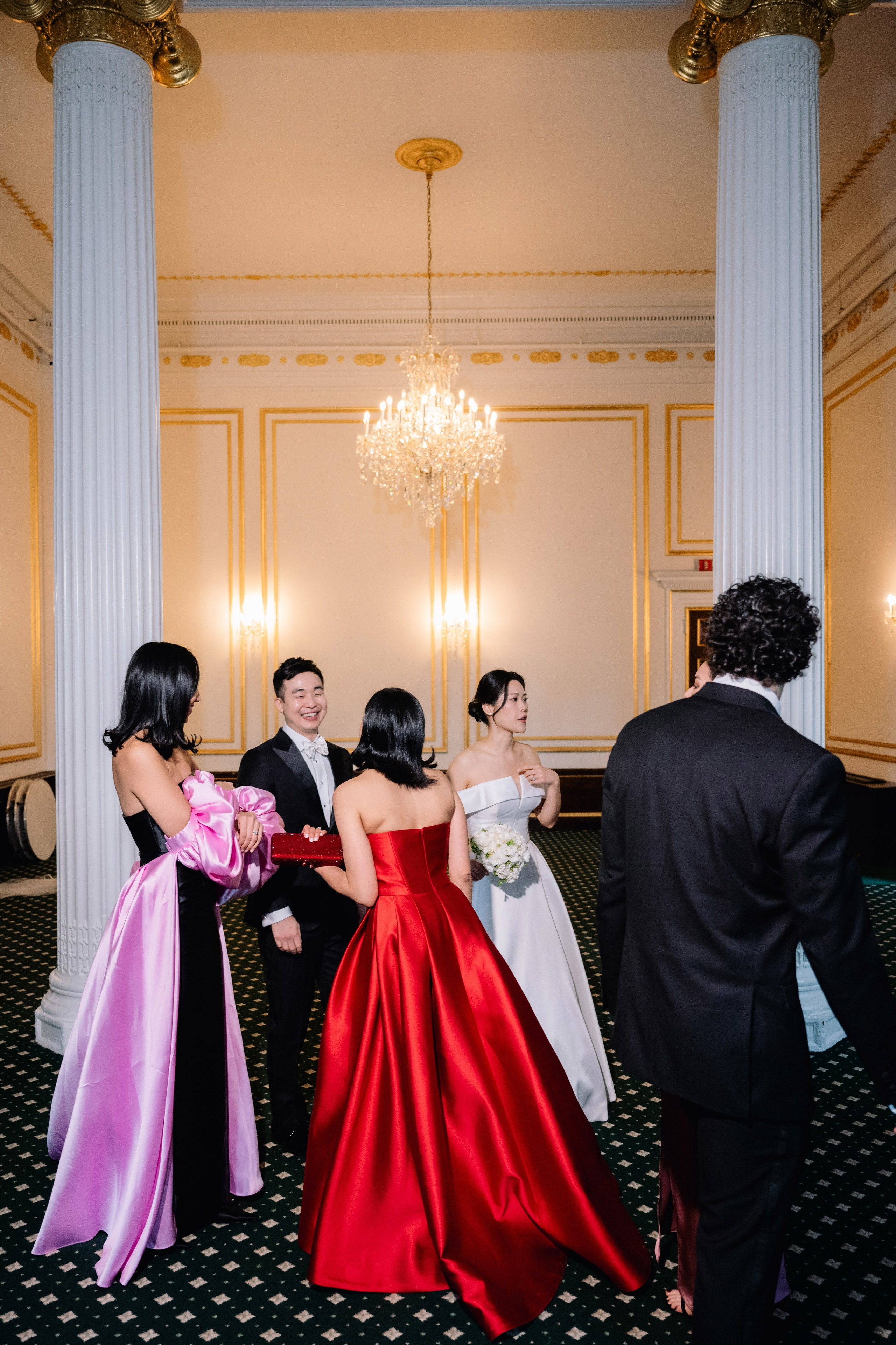 a group of people standing around a woman in a red dress