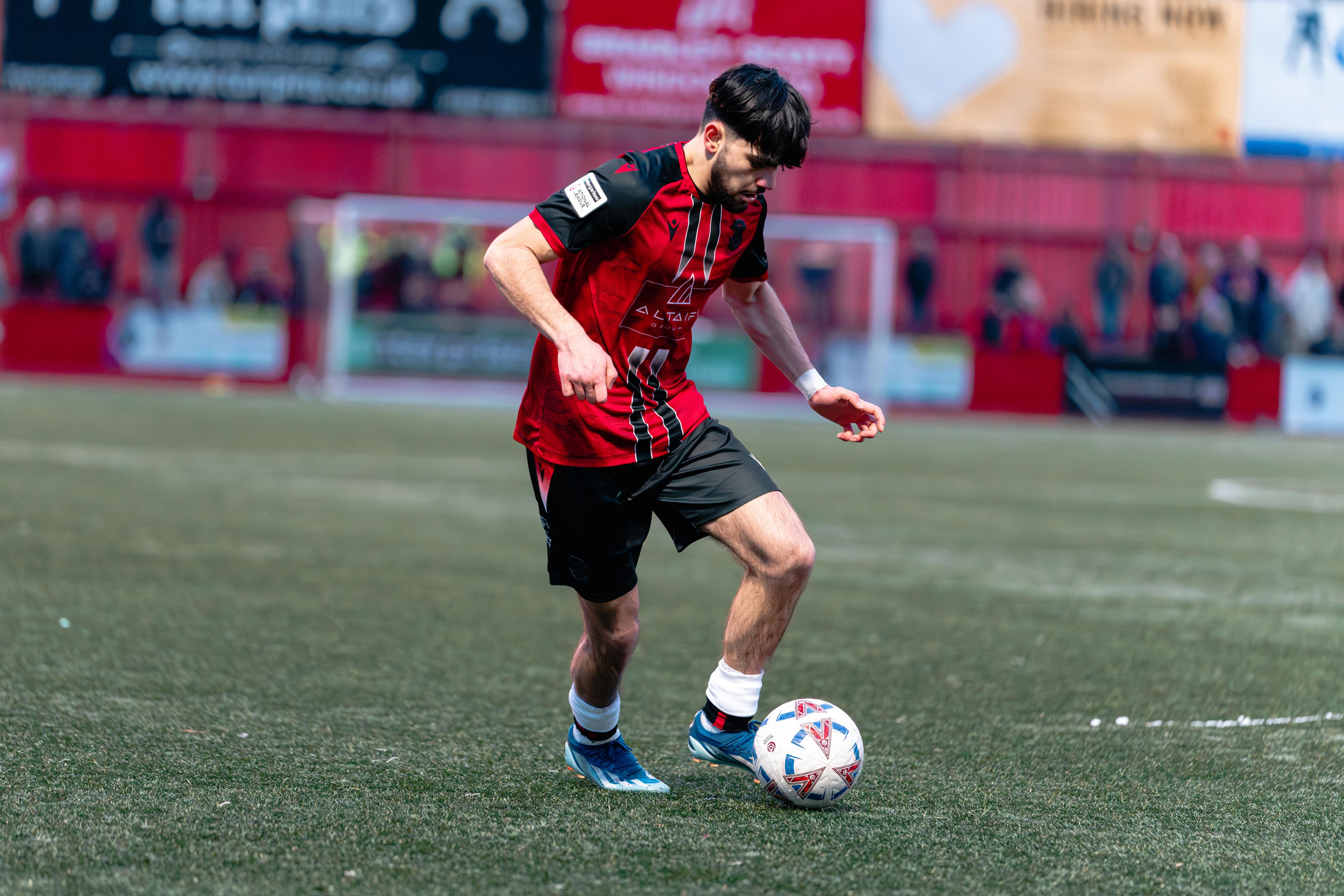 Tamworth’s Ronan Maher brings the ball under control on the pitch during open play.
