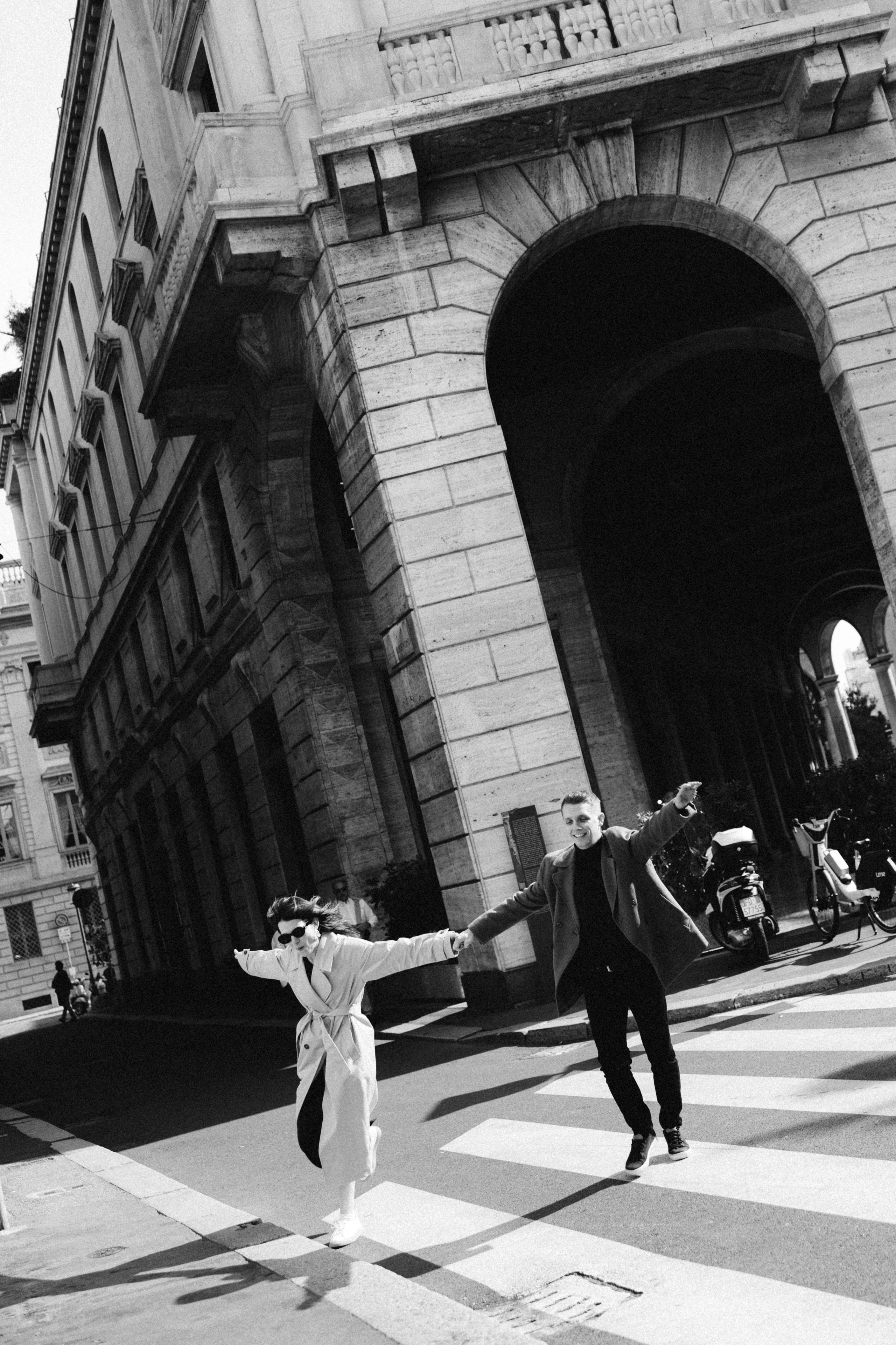 Couple running through Milan streets during love story photoshoot