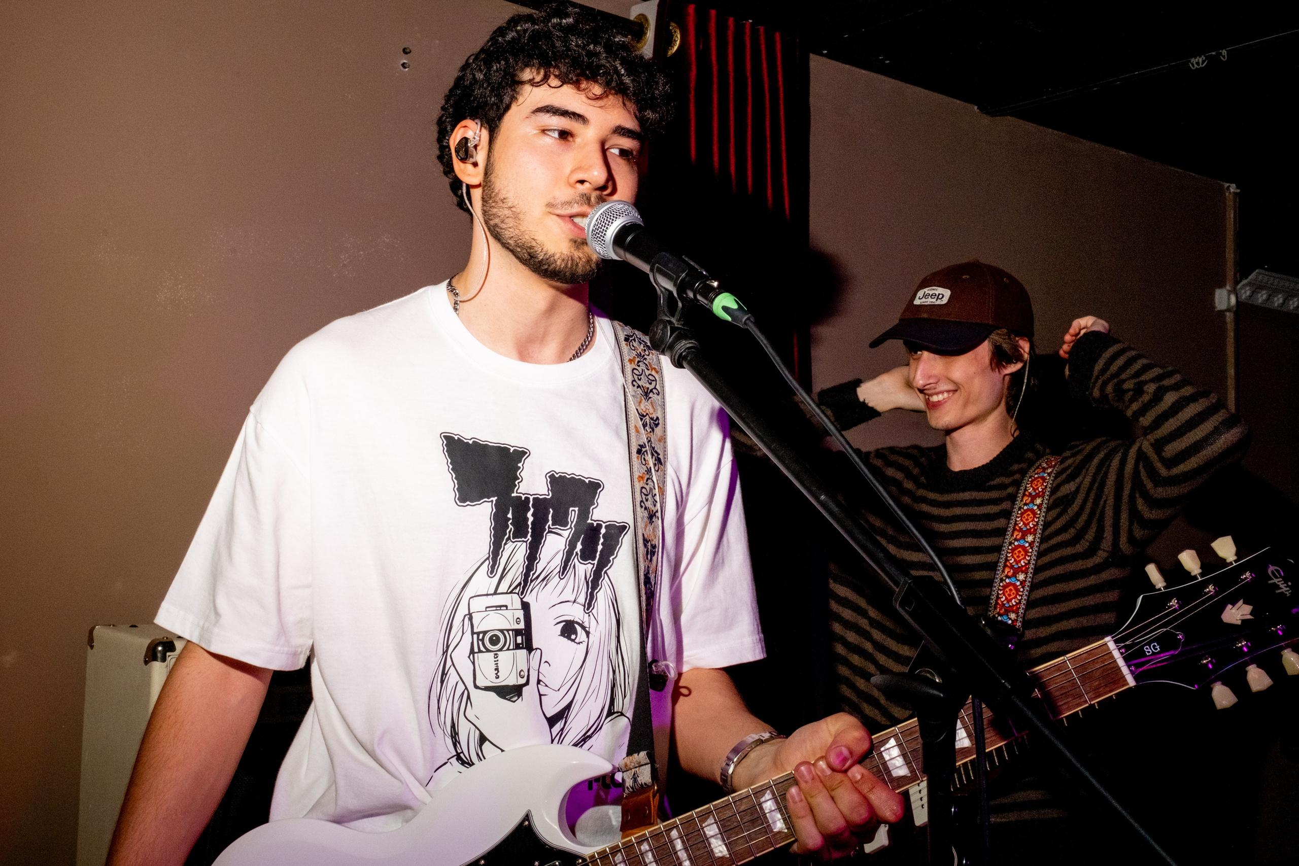 Keyingi Safar: guitarist in a white T-shirt singing into the microphone — Boshqa Musiqa Fest, Ponaexali Hall, Tashkent, September 2026