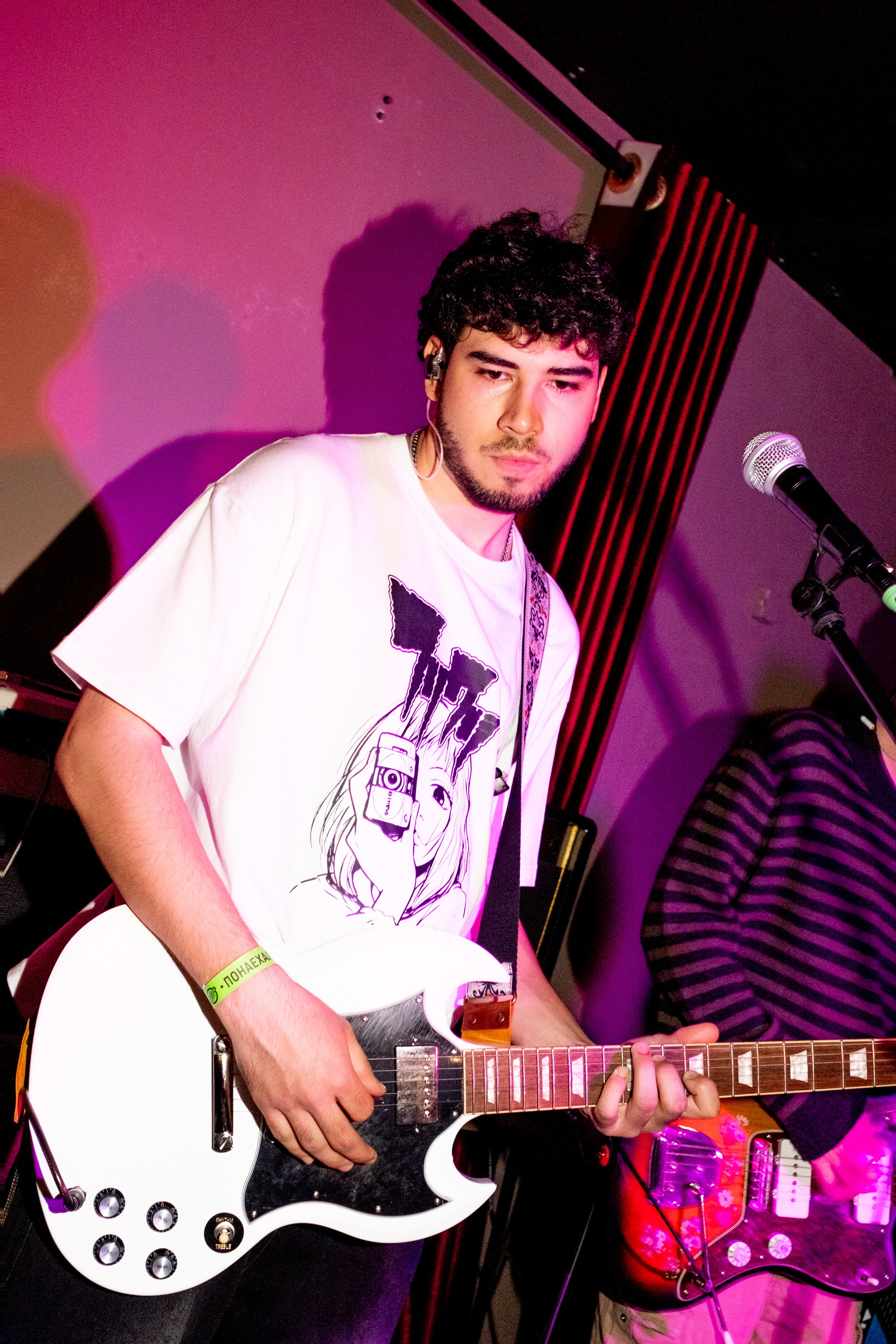 Keyingi Safar: guitarist in a white T-shirt looking down at his guitar — Boshqa Musiqa Fest, Ponaexali Hall, Tashkent, September 2026