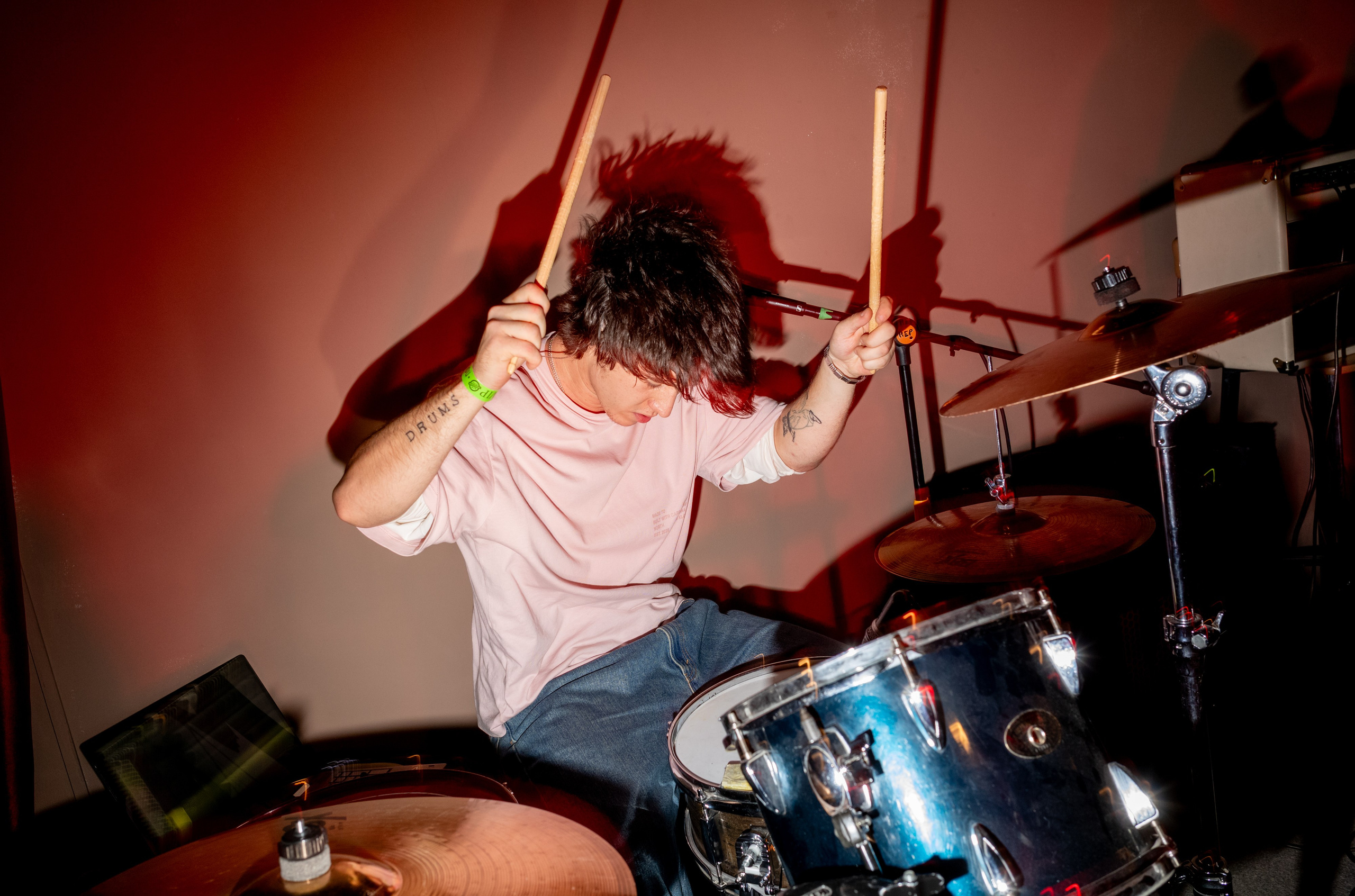 Keyingi Safar: drummer playing under red light — Boshqa Musiqa Fest, Ponaexali Hall, Tashkent, September 2026