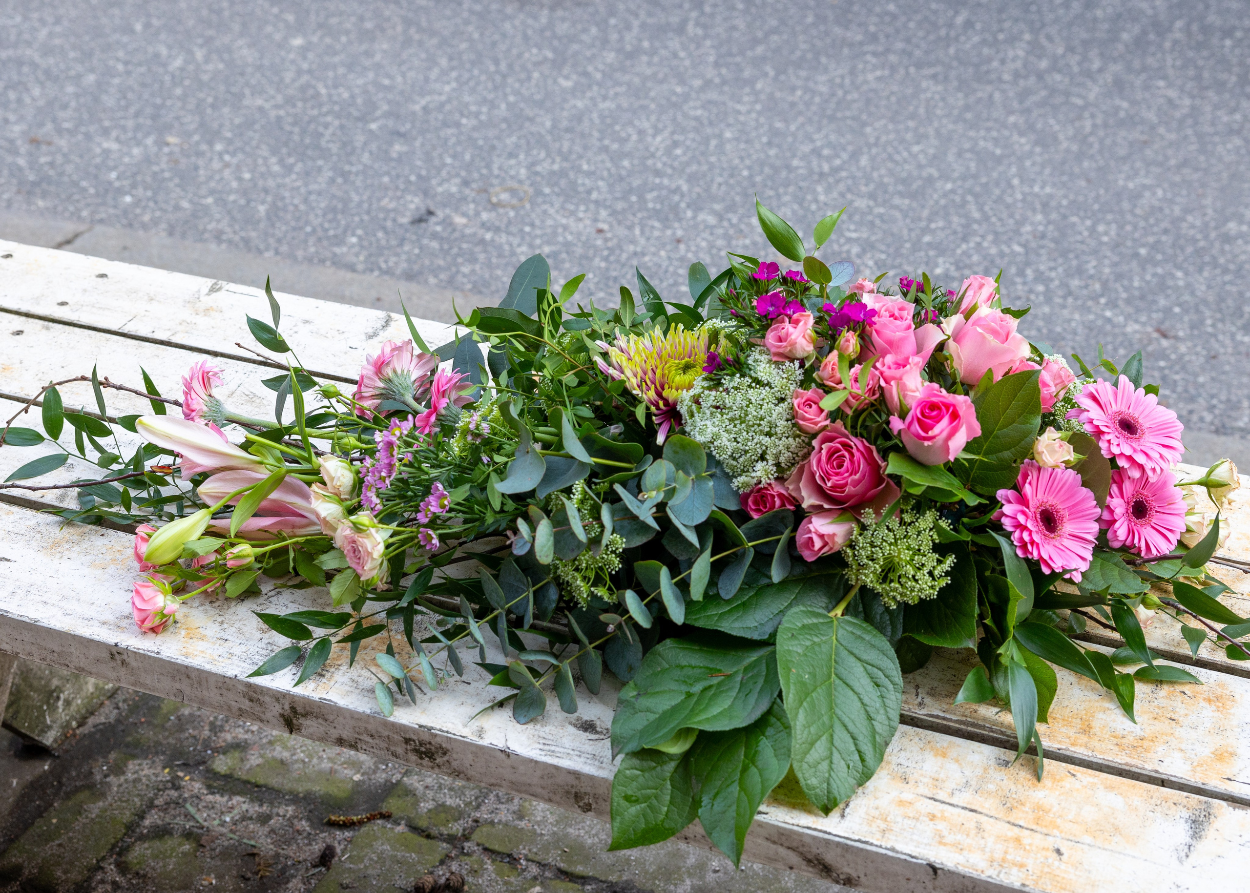 Elegant båredekoration, hvor blomsterne er arrangeret med højde og længde. Dekorationen er afstemt i lyserøde nuancer, flot til alle årstider. En smuk sidste hilsen, der tager sig flot ud på kirkegulvet. 