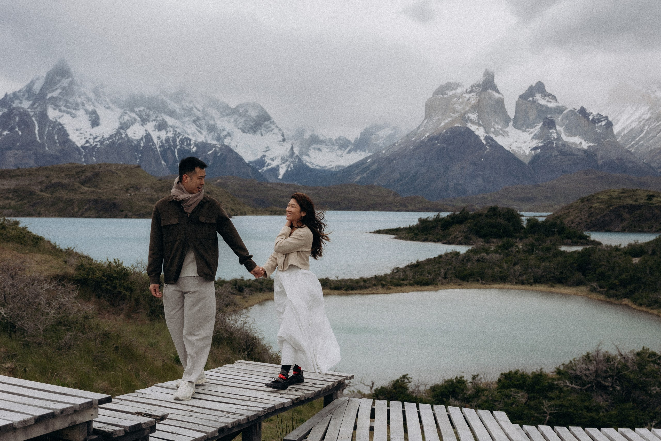 Couple walking on boardwalk above Patagonia lakes