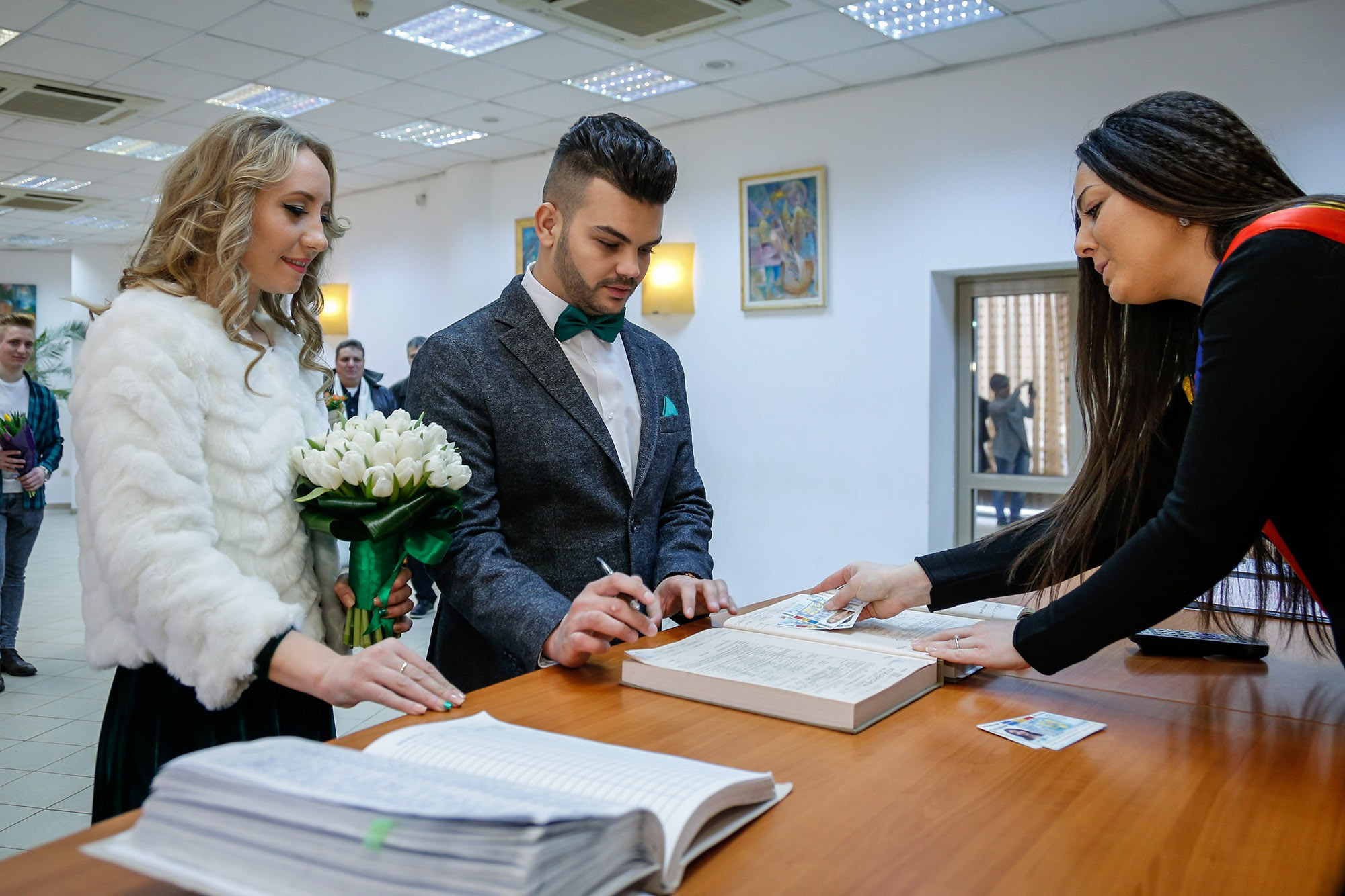 The groom officially signing the marriage registry during the civil ceremony, an essential detail captured by the event photographer.