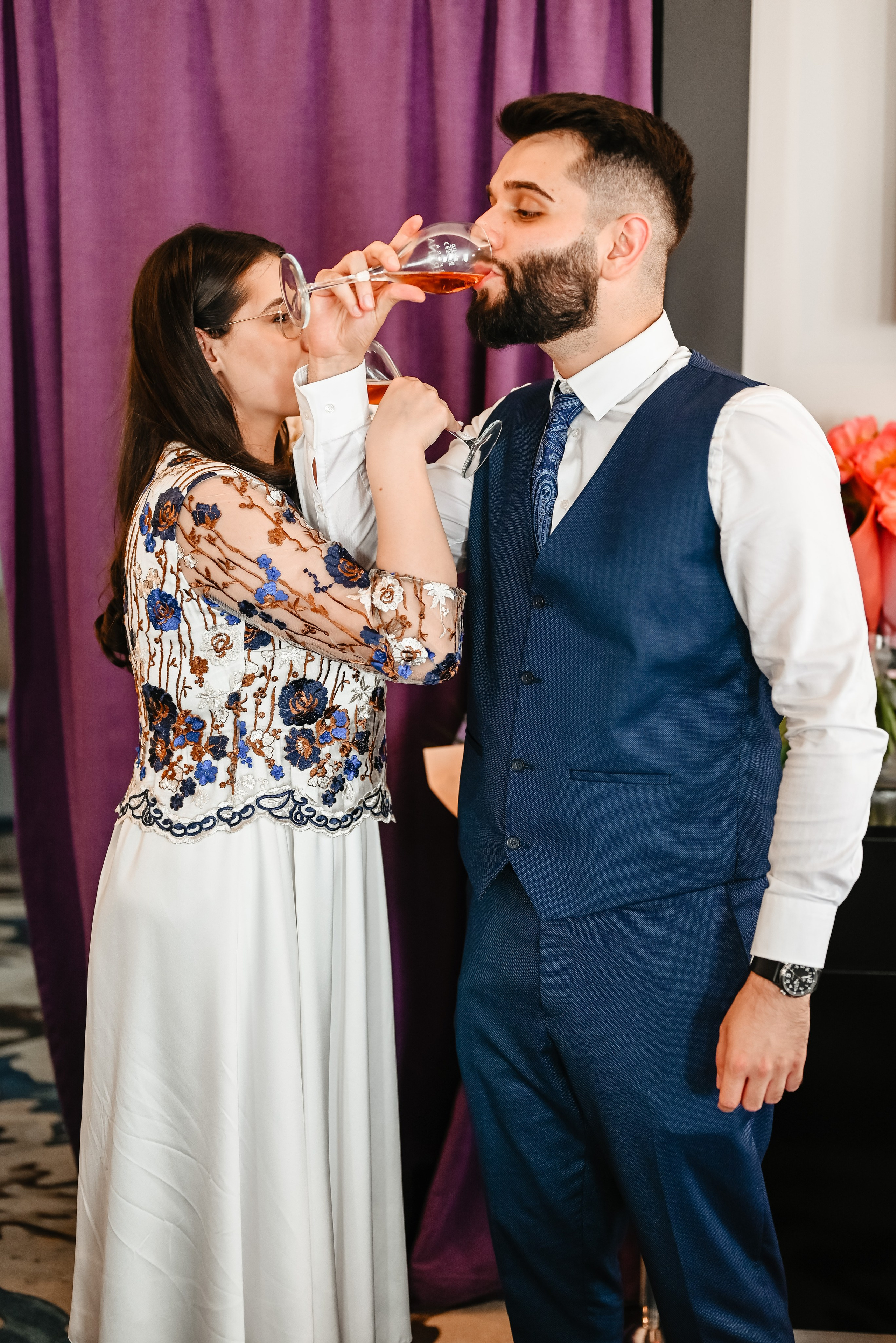 Moment candid cu mirii ciocnind pahare de șampanie alături de familie, într-o atmosferă intimă – fotografie de Ana Maria Drăgan.