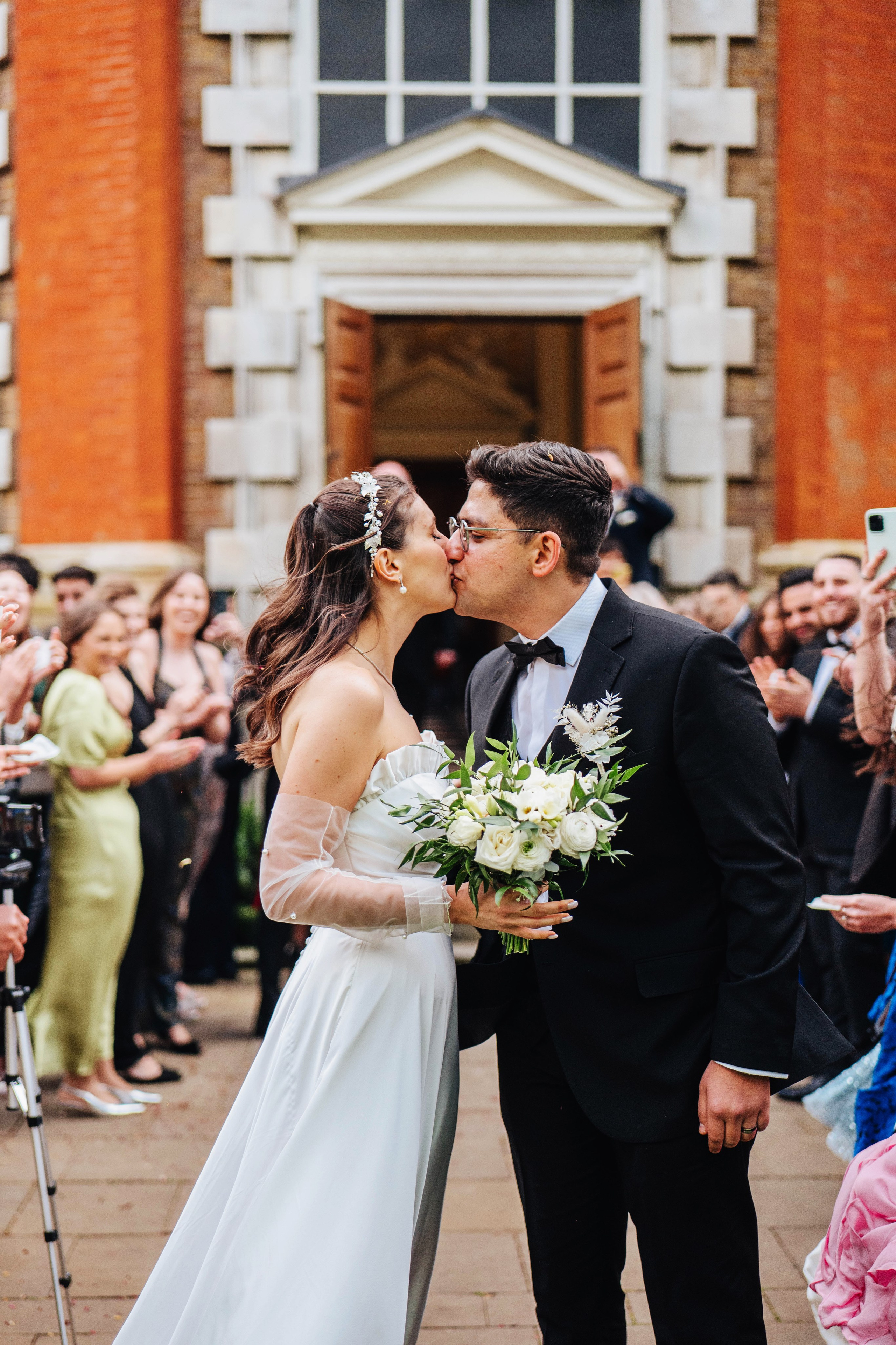 photo of the wedding ceremony, close up of bride and groom kissing after the confetti