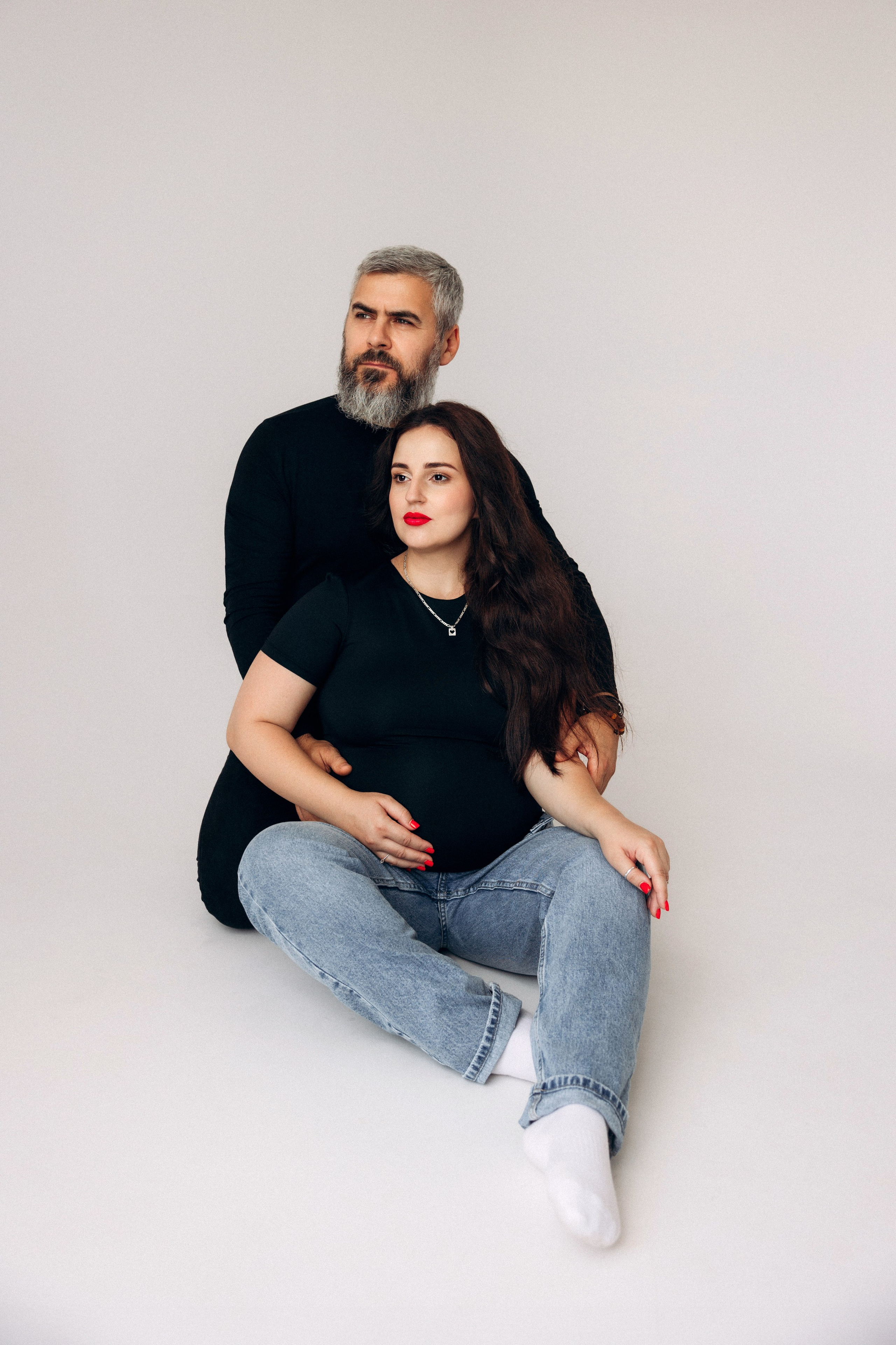 Spokój i koncentracja – kobieta w ciąży siedzi w studio, skupiona na nowym życiu.