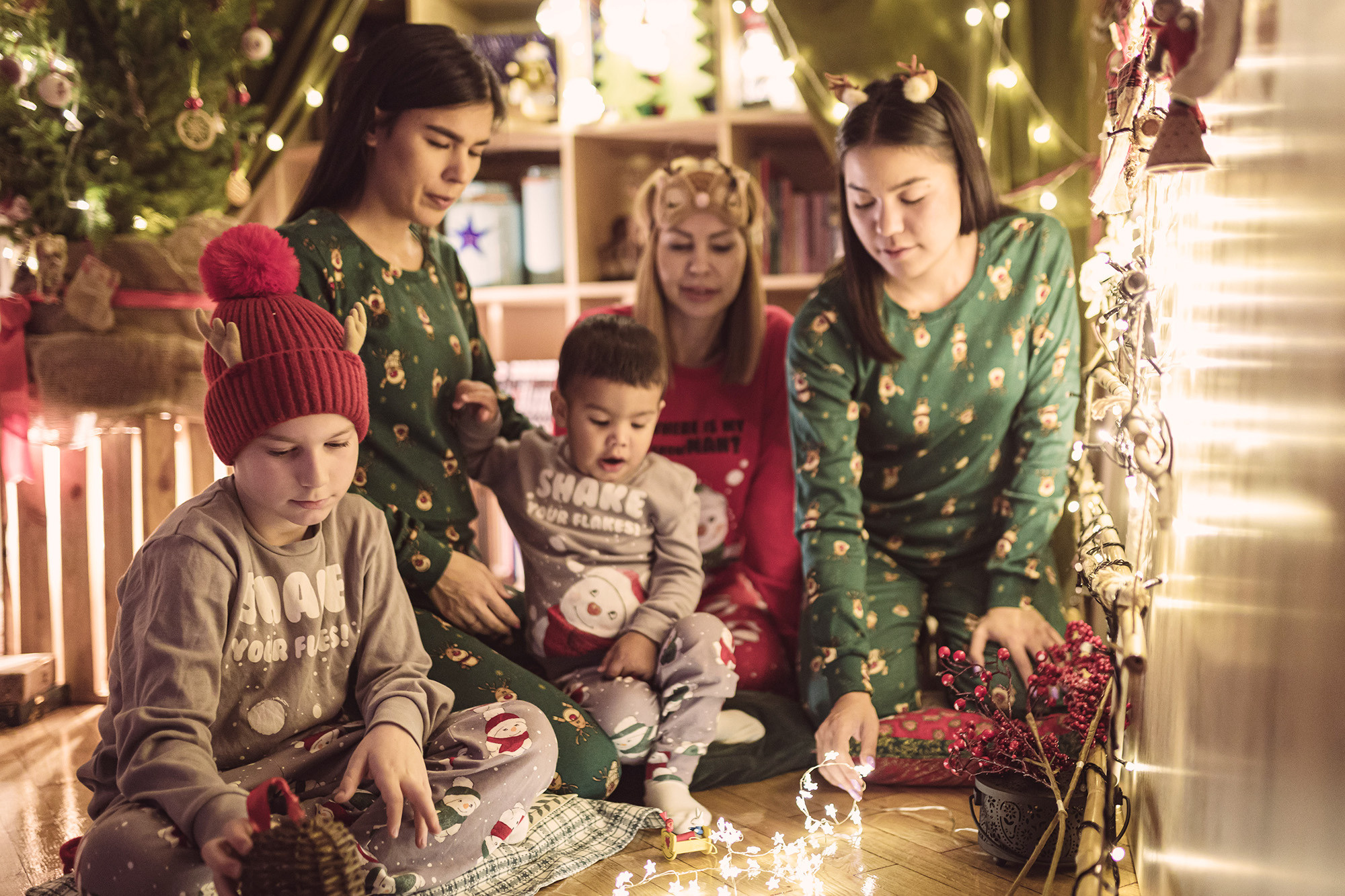Porodična slika sa novogodišnjim dekoracijama u studiju.