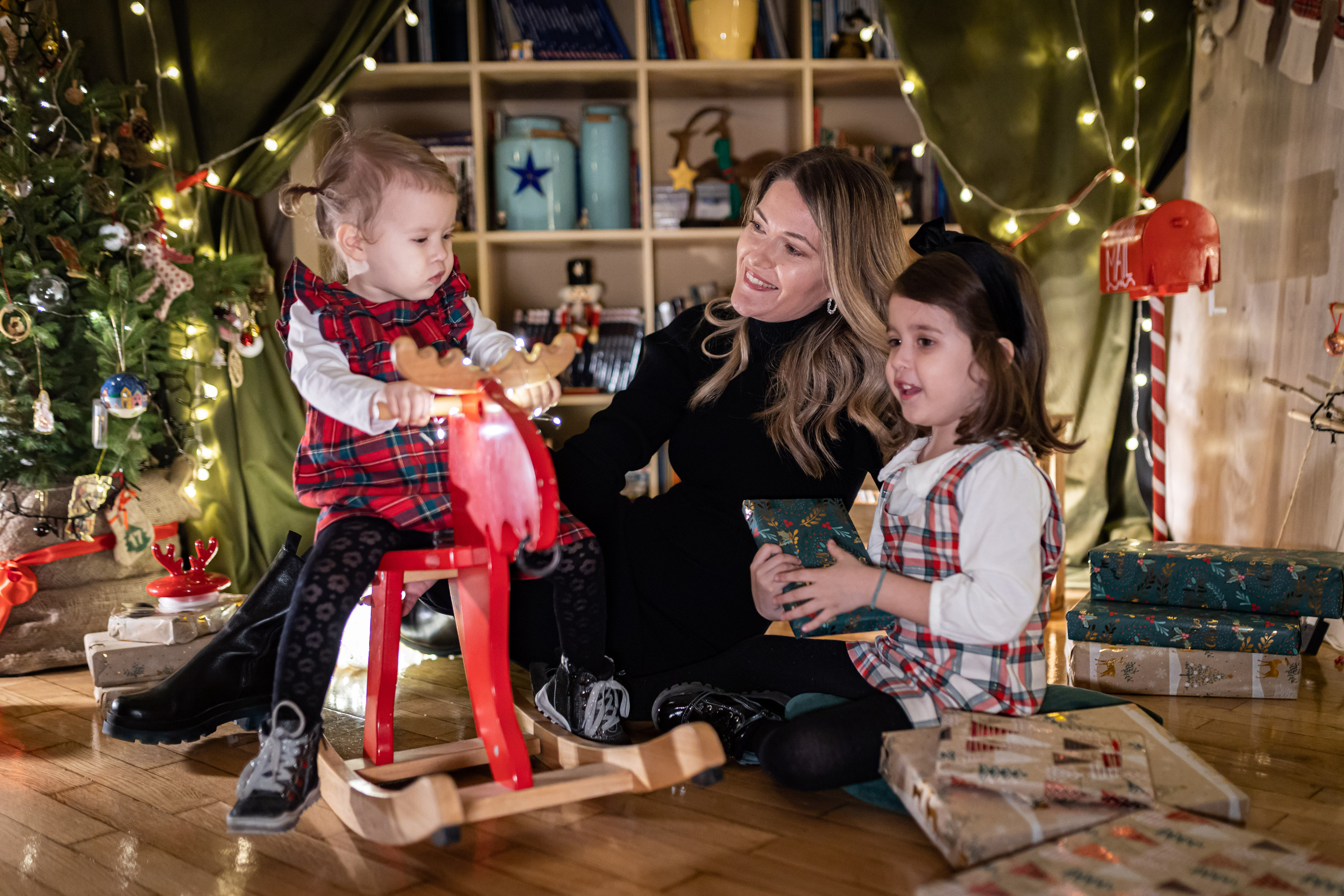 Porodična slika sa novogodišnjim dekoracijama u studiju.