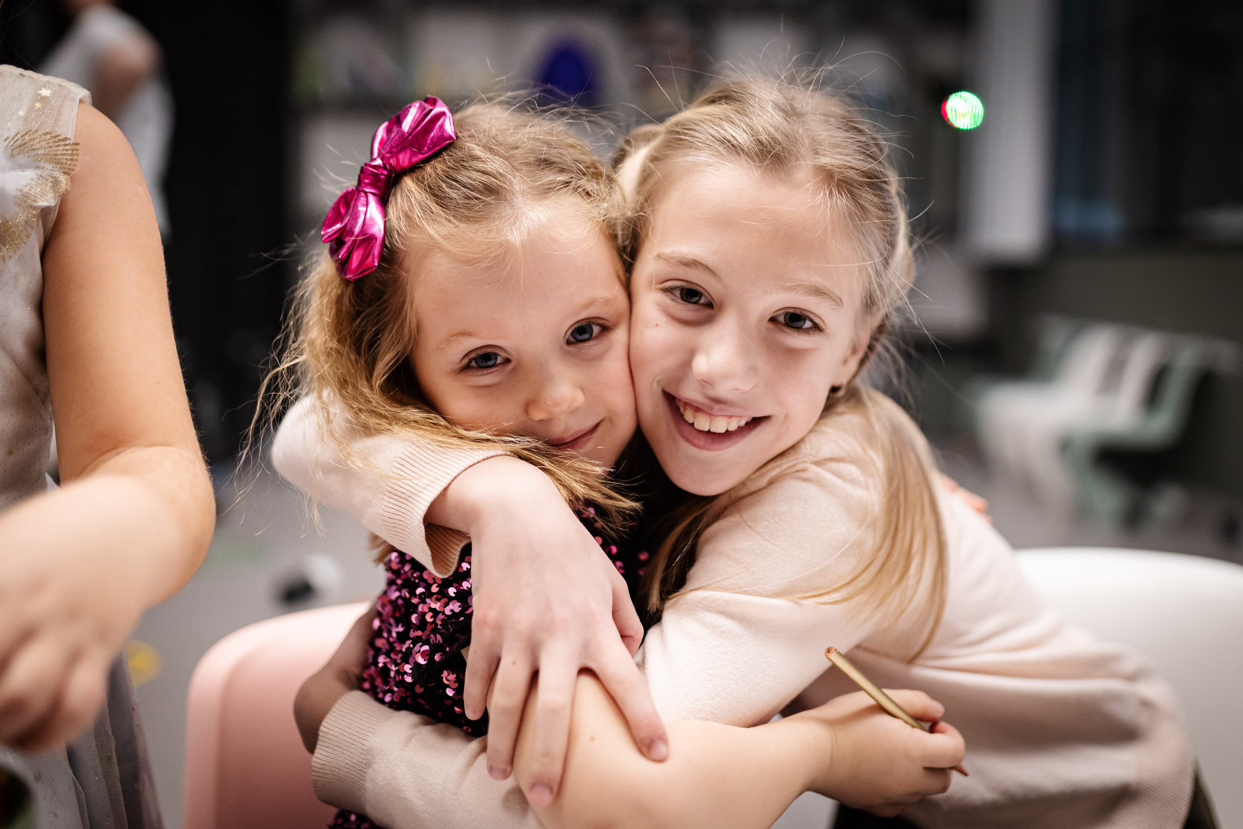 fotografija dve zagrljene nasmejane devojčice