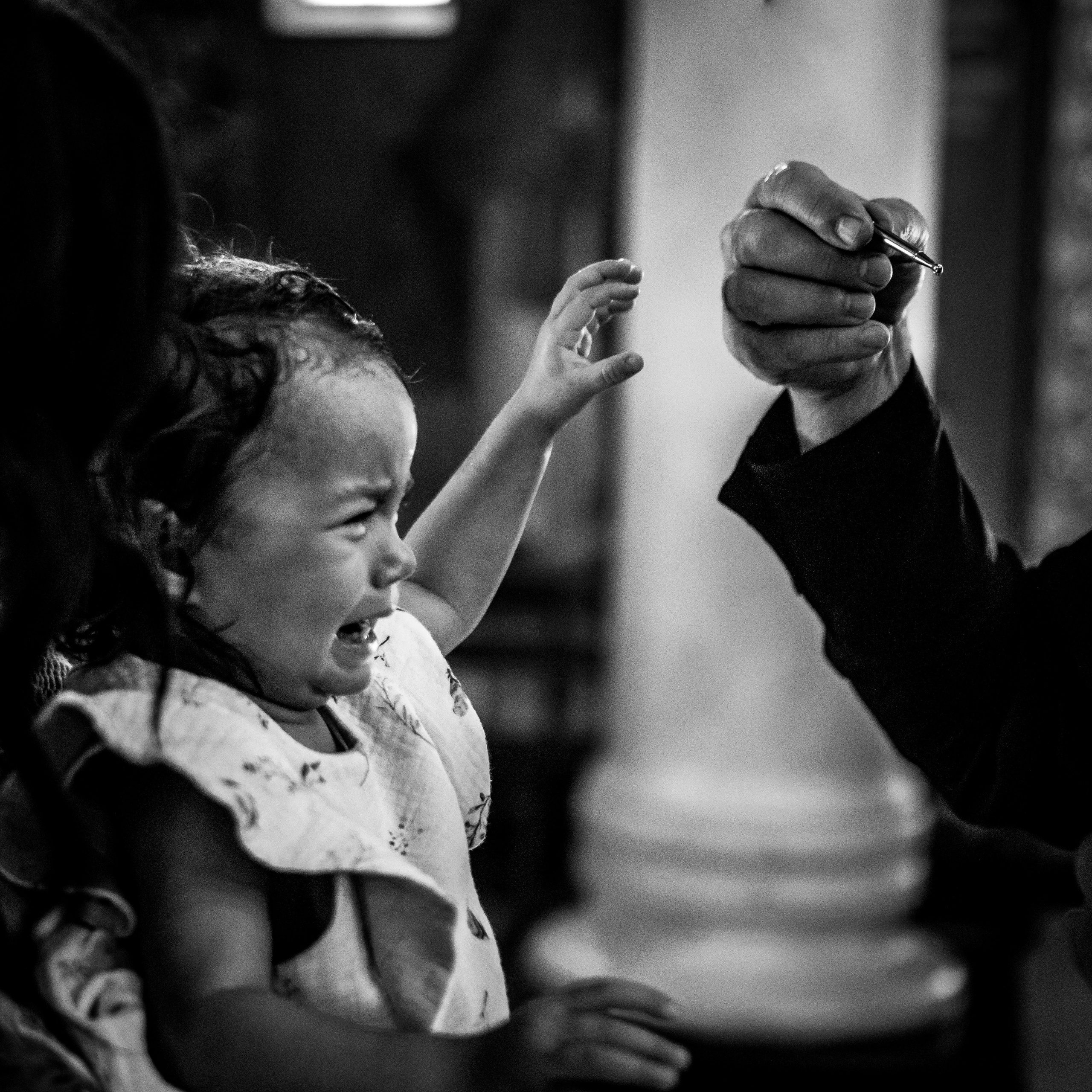 crno-bela fotografija uplakane devojčice sa krštenja