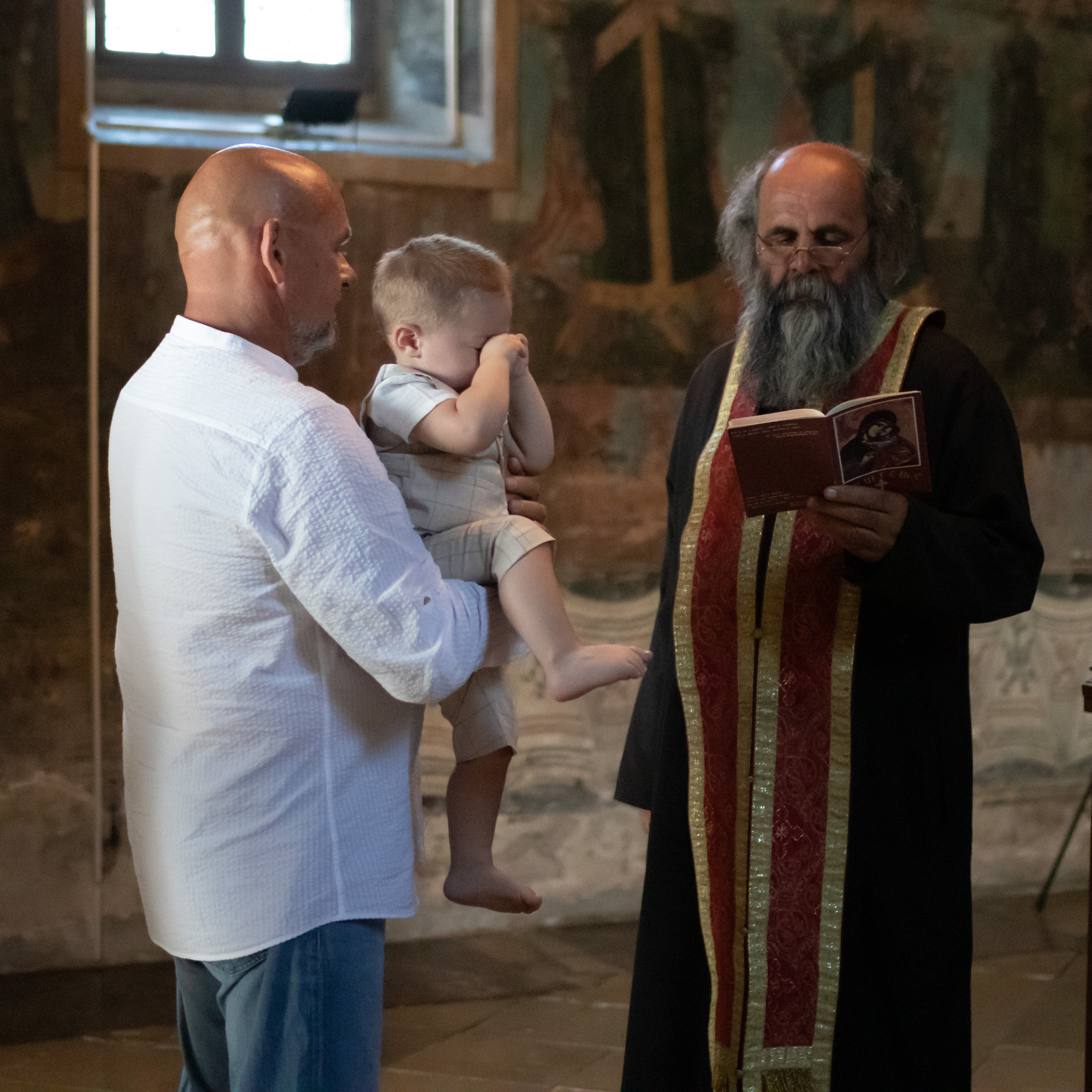 fotografija uplakanog dečaka na krštenju