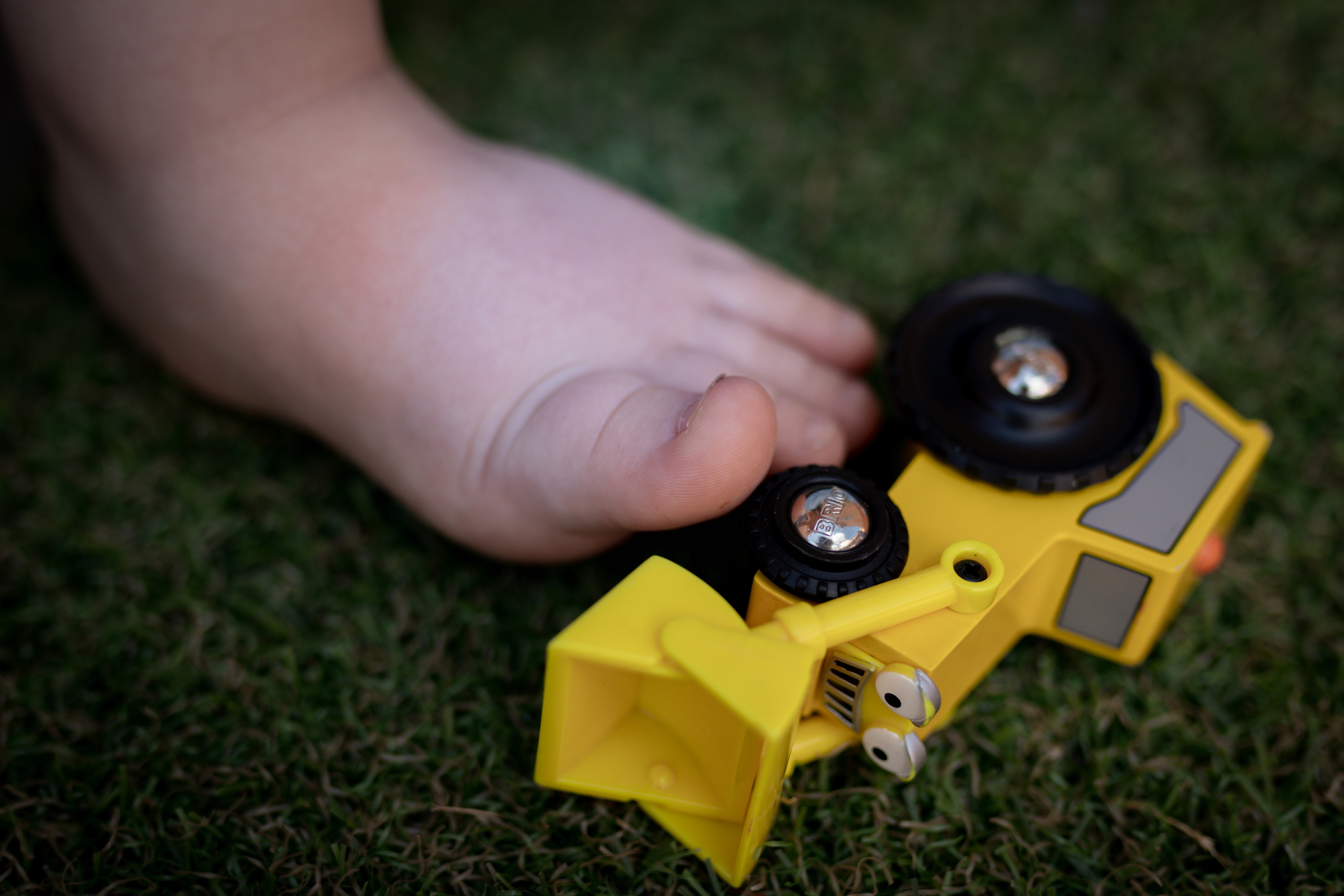 fotografija stopala dečaka i igračke 